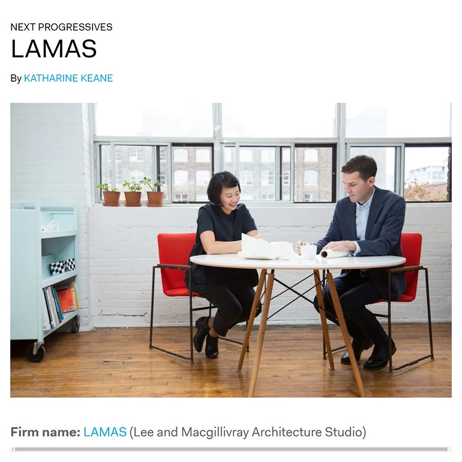 Two people, a woman and a man, sitting at a white table in a bright room with large windows, celebrating or working, with papers and containers on the table.