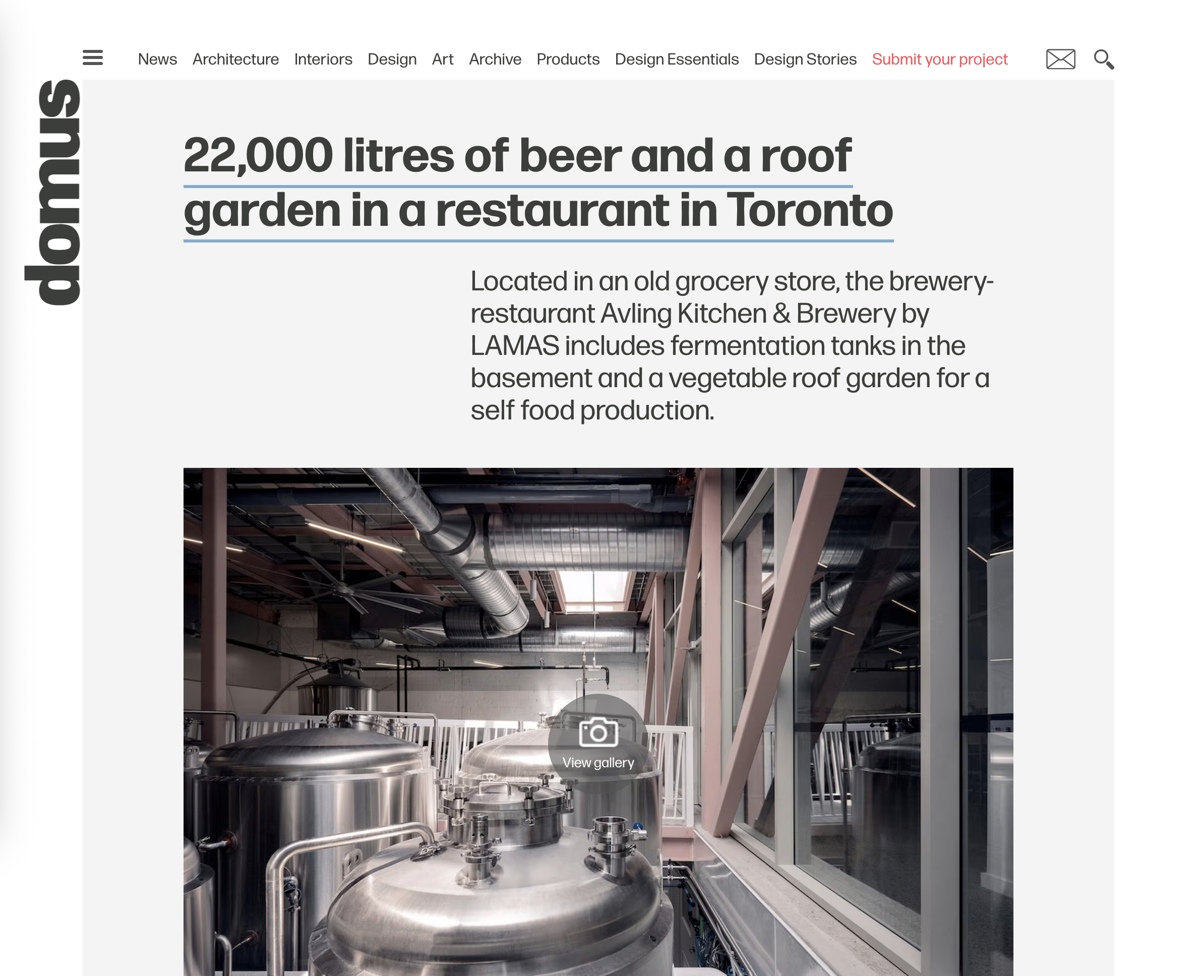 Industrial brewery equipment with fermentation tanks inside a brewery, with large metal tanks, pipes, and ventilation ducts.