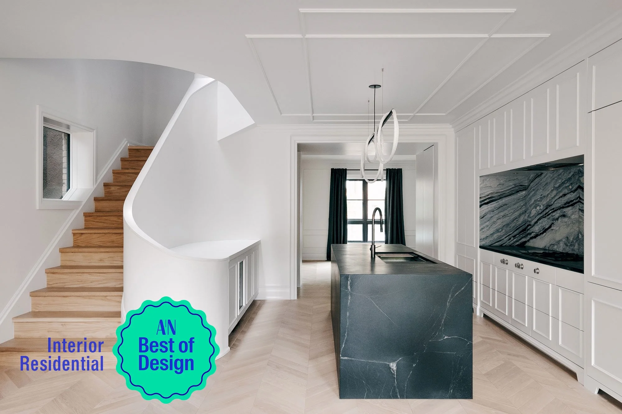 Modern kitchen with a black marble island, white cabinetry, a stainless steel sink, black curtains, and a staircase with wooden steps.