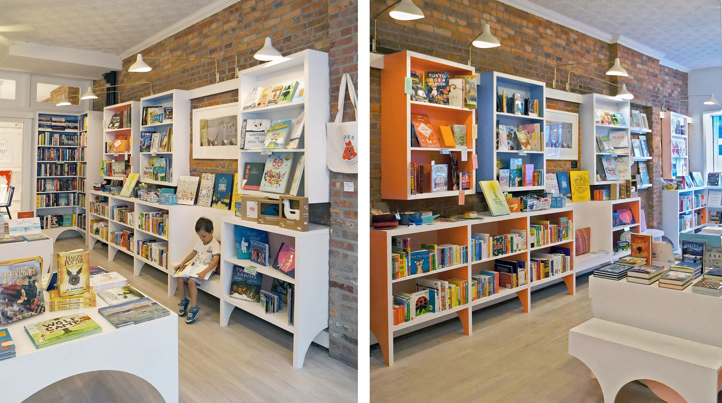 Interior of a bookstore with white and orange bookshelves filled with children's books, a small child sitting on the floor reading, exposed brick walls, ceiling lights, and a large window letting in natural light.