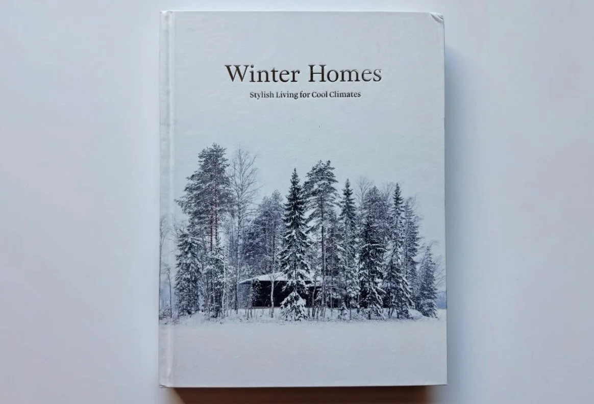 Book titled "Winter Homes" with a snowy forest scene on the cover, featuring trees and a small cabin.