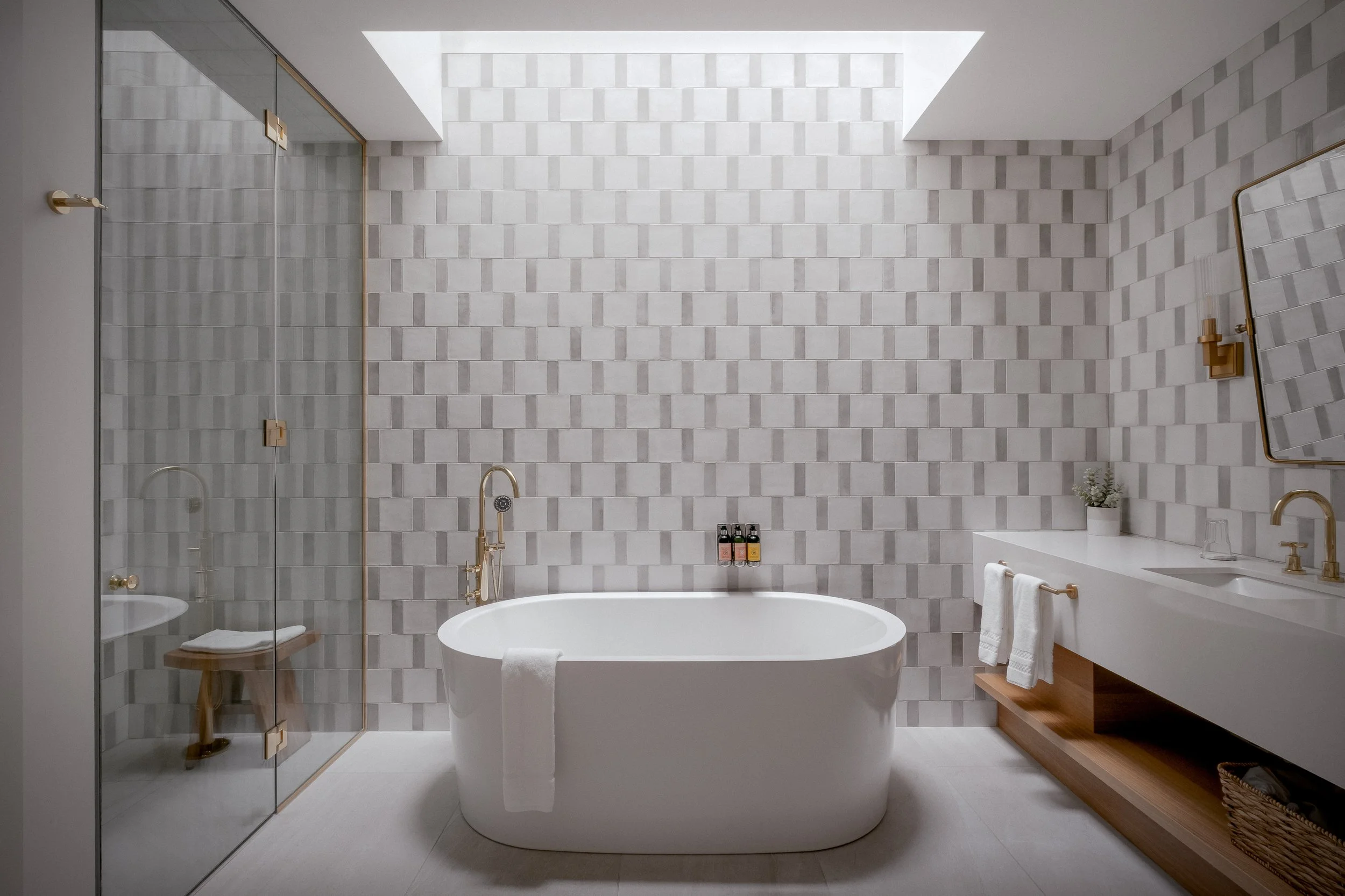 Modern bathroom with a freestanding bathtub, a glass shower room, a white vanity with a mirror, and neutral-toned tiled walls.