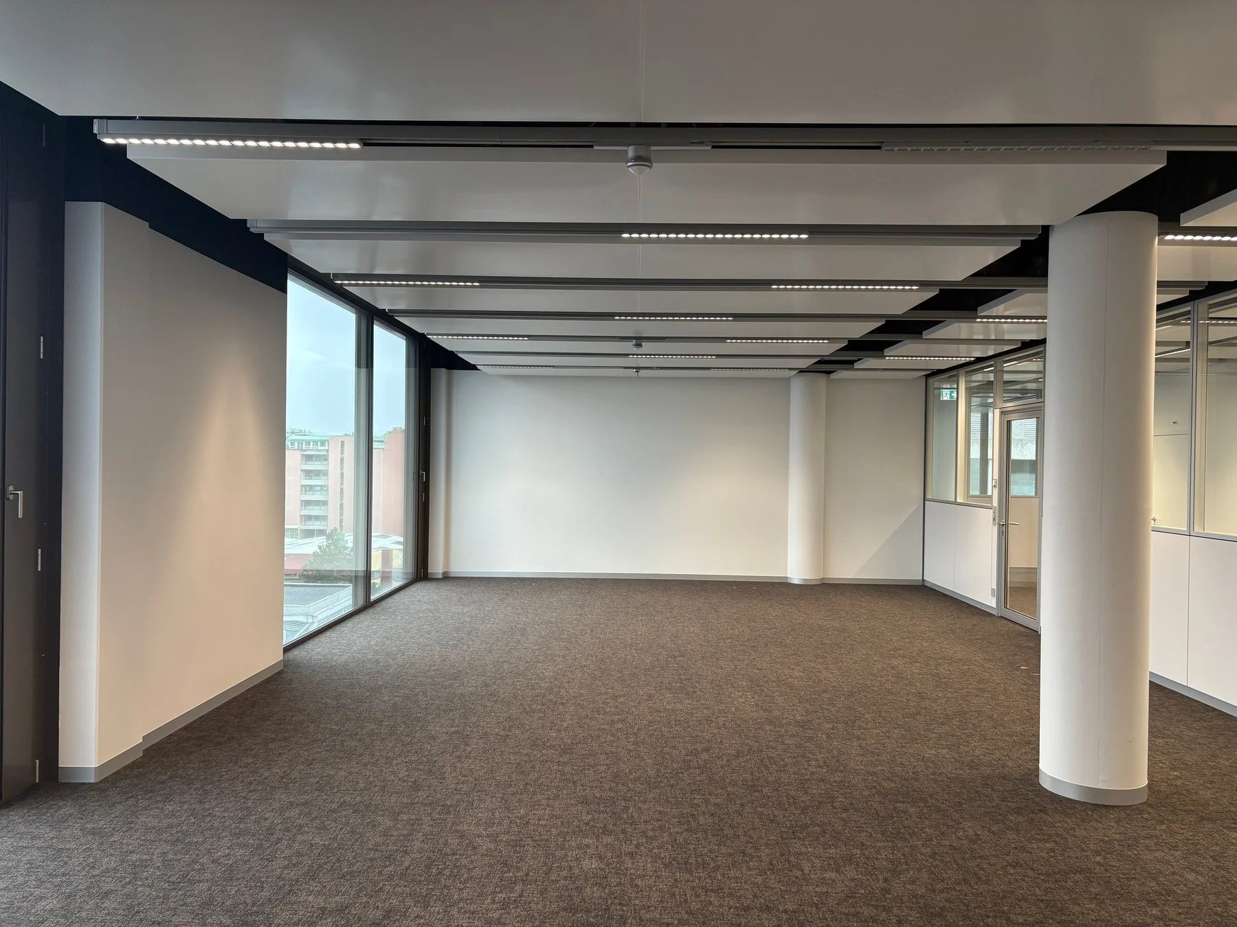 Plateau de bureaux à Genève avec faux-plafond et éclairage linéaire intégré, aménagement intérieur réalisé par DSD SA