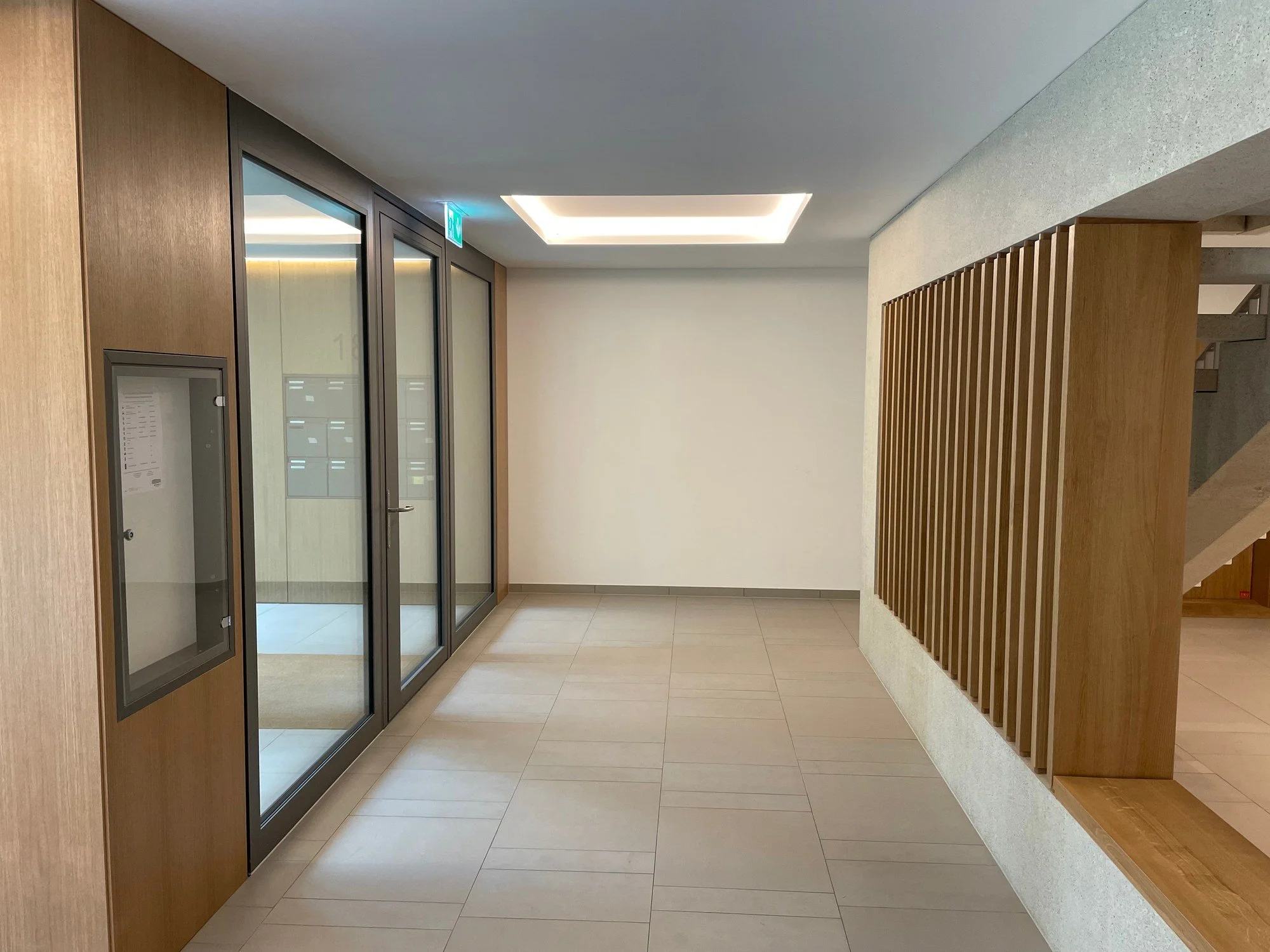 Faux-plafond avec caisson lumineux encastré et peinture des parois réalisés par DSD SA dans le hall d'entrée d'un immeuble de 50 logements à Genève