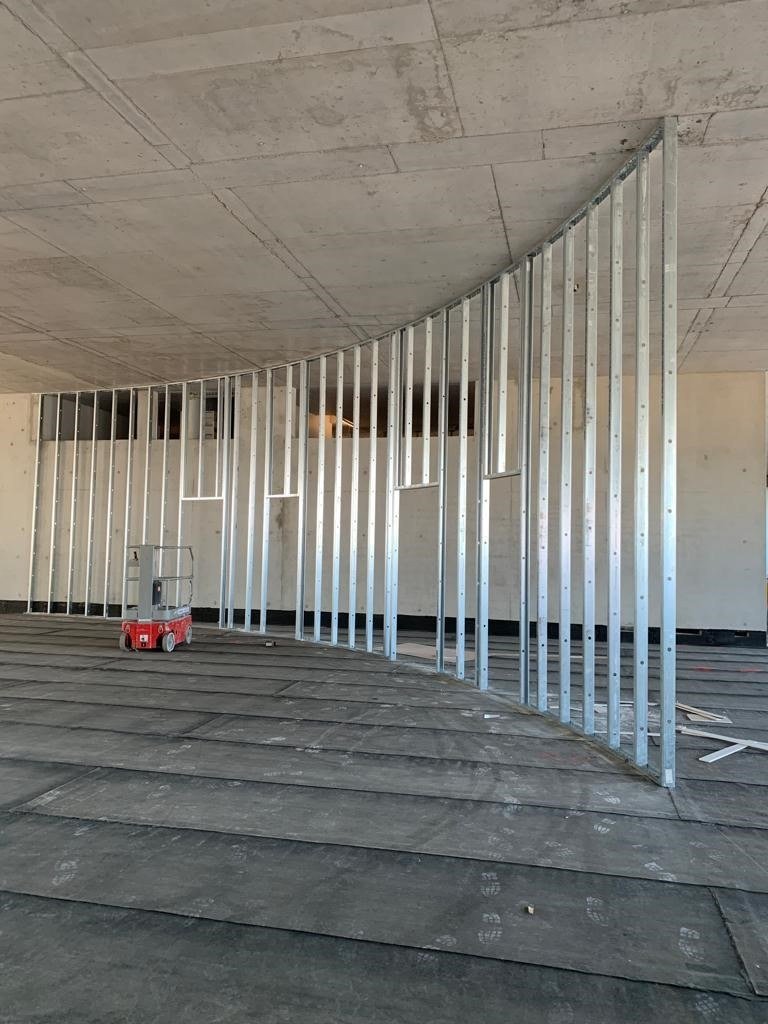 Ossature métallique en cours de montage pour une cloison cintrée sur un chantier DSD SA à Genève