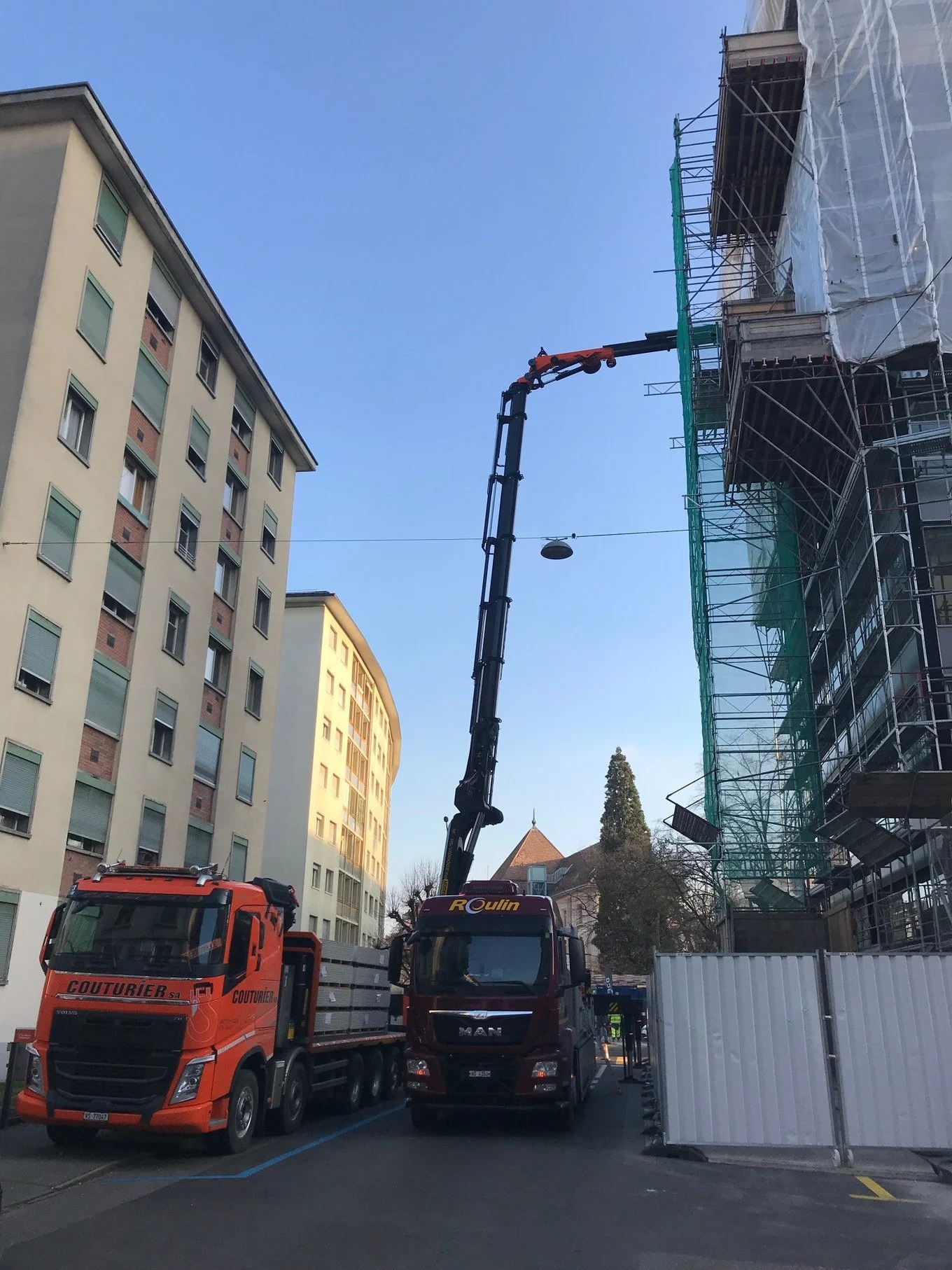 Livraison de matériaux par grue sur un chantier de surélévation