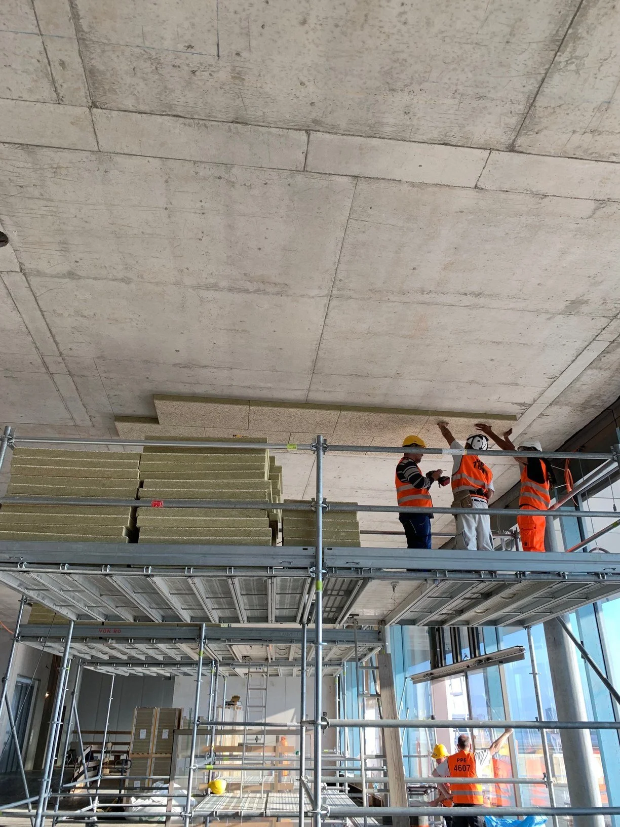 Équipe DSD SA installant des panneaux d'isolation thermique en laine de roche sur échafaudage lors d'un chantier à Genève