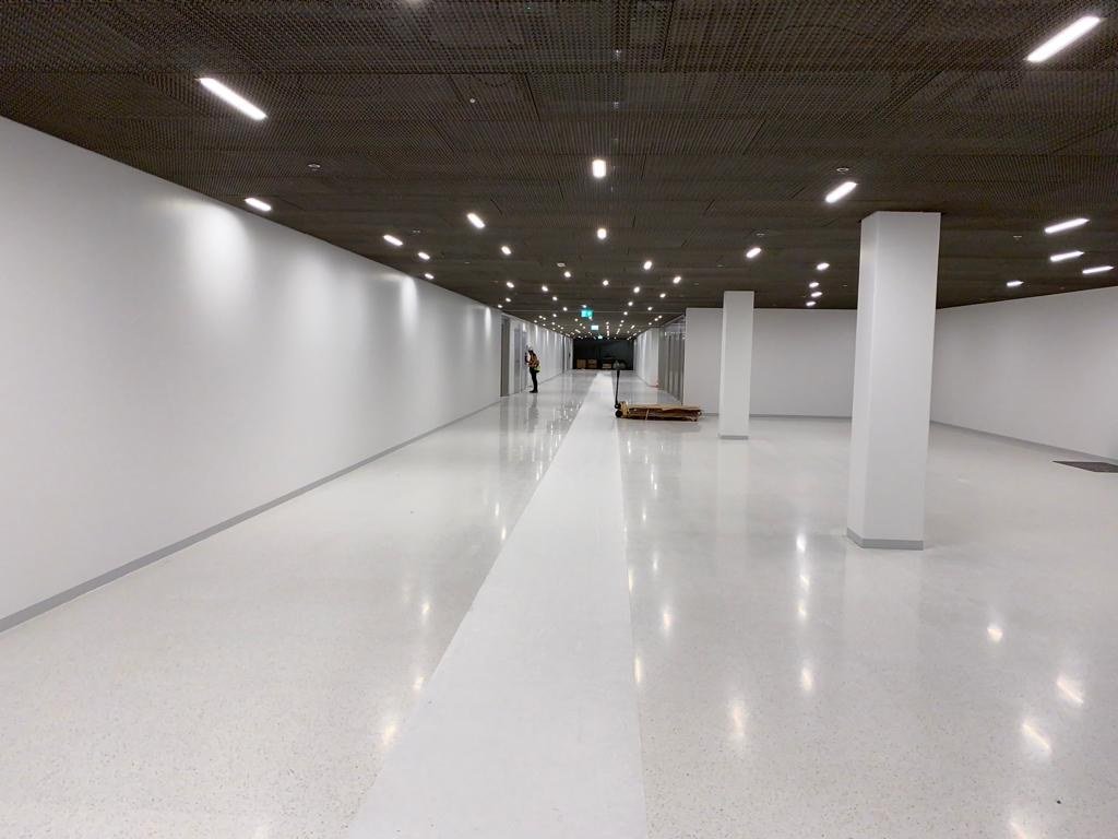 Couloir en sous-sol avec enduits plâtre lisses et peinture satinée réalisés par DSD SA dans un espace horloger à Genève
