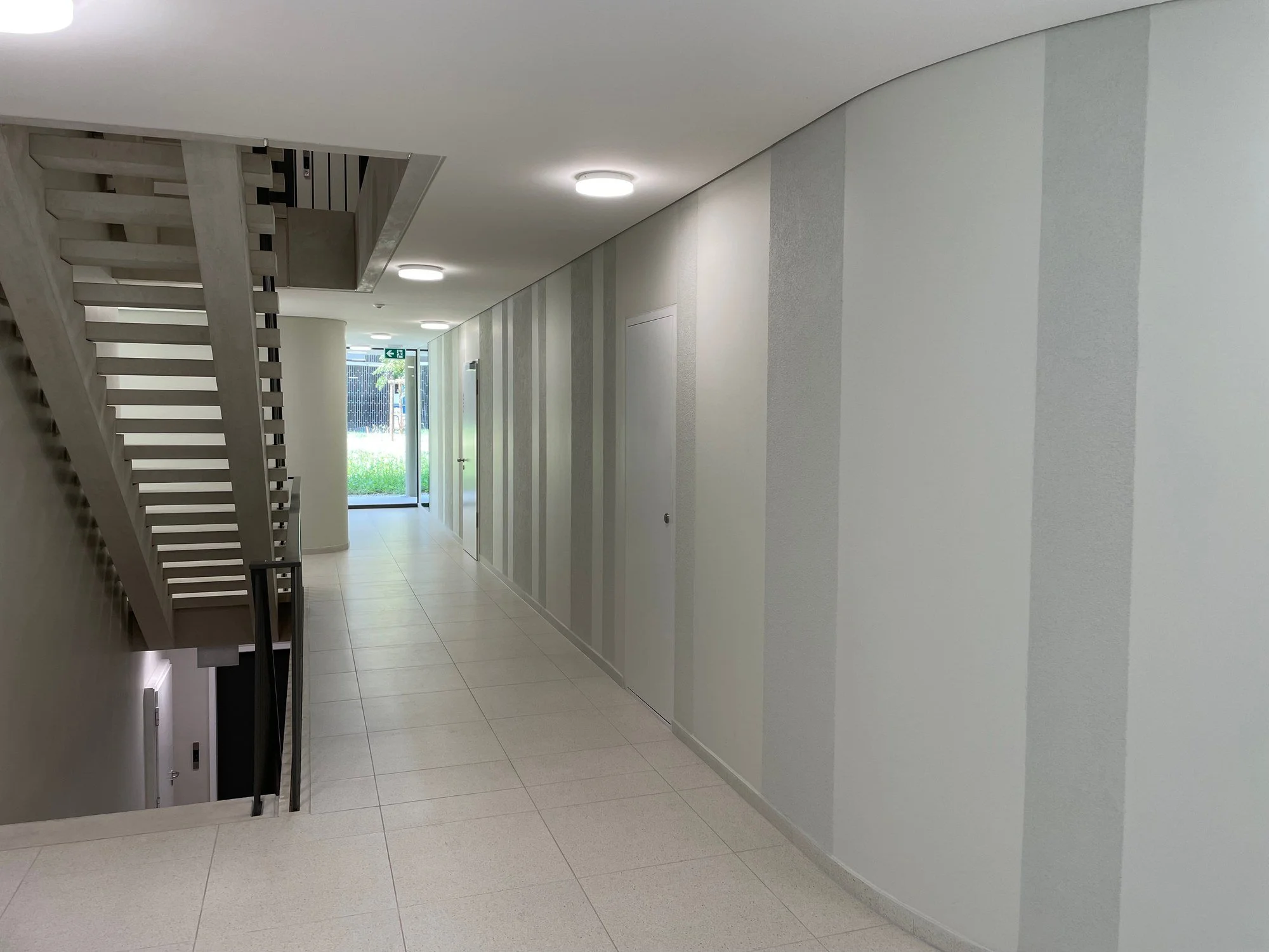 Couloir rénové avec cloisons, faux-plafonds et peinture décorative réalisés par DSD SA dans un immeuble d'habitation à Genève
