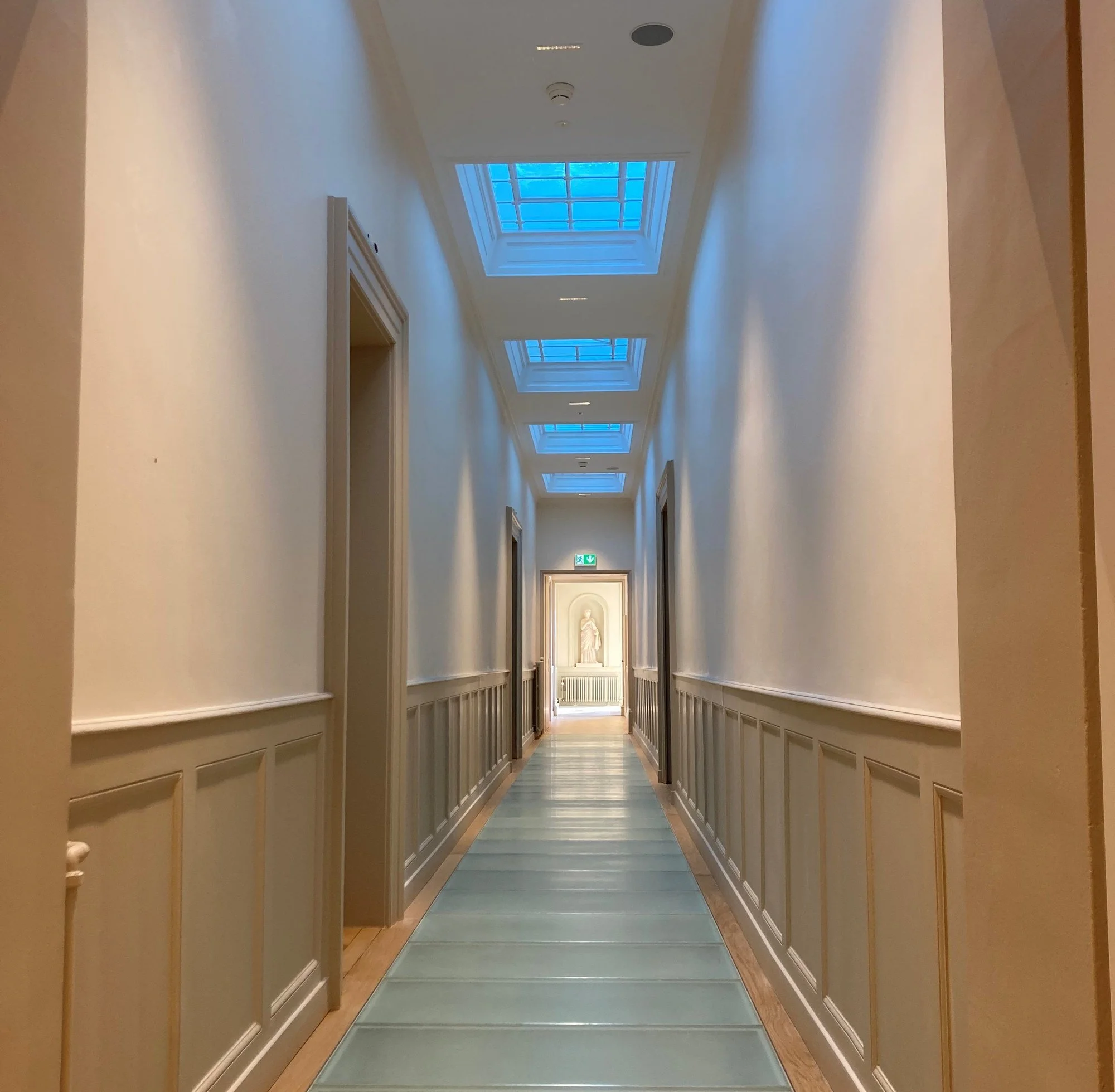 Couloir du Conservatoire de musique à Genève avec enduits plâtre, réparation corniches et peinture satinée réalisés par DSD SA