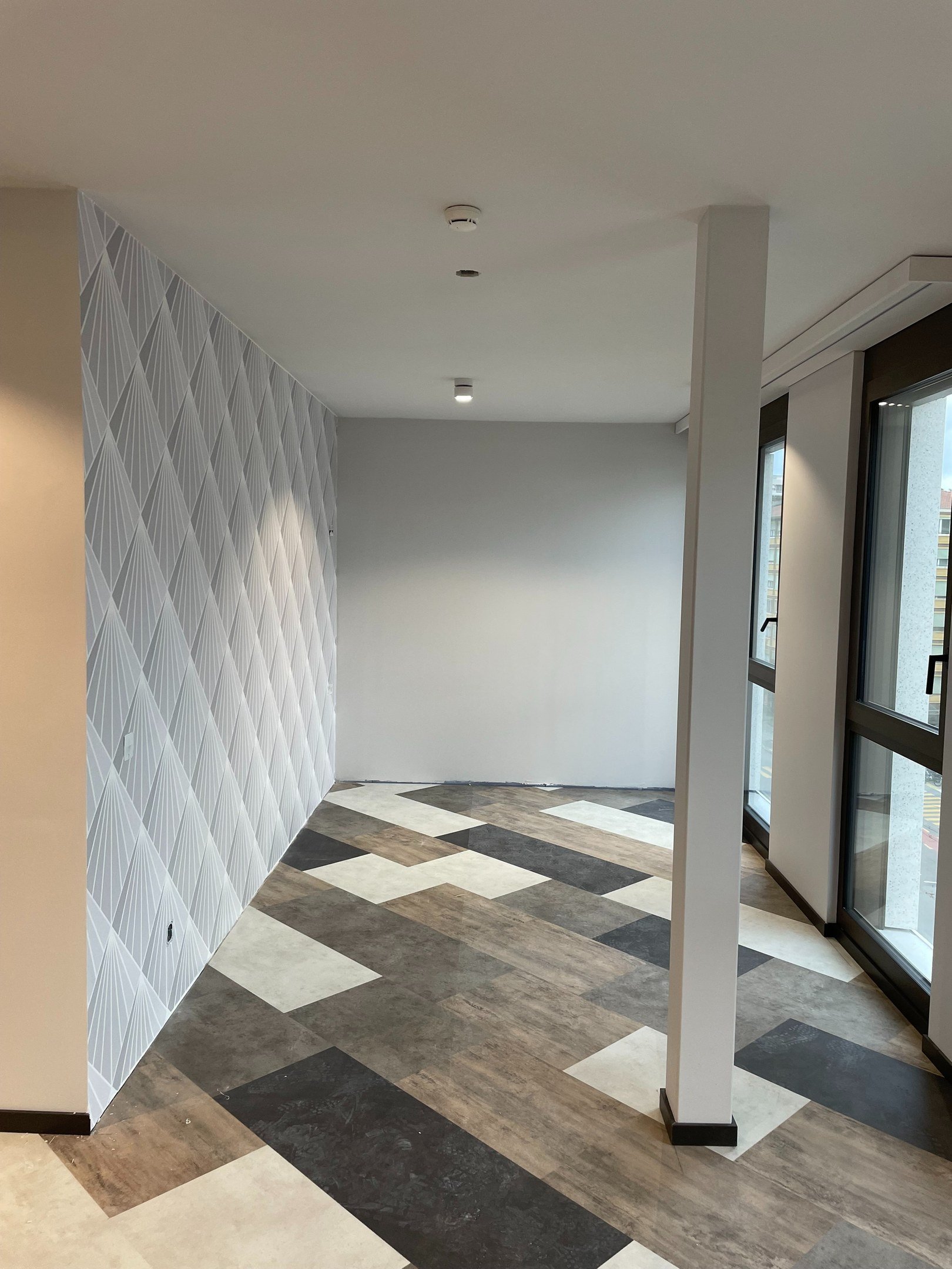 Chambre d'hôtel avec cloisons, faux-plafonds, peinture décorative et pose de papier peint réalisés par DSD SA pour l'Hôtel Stay Kooook à Genève