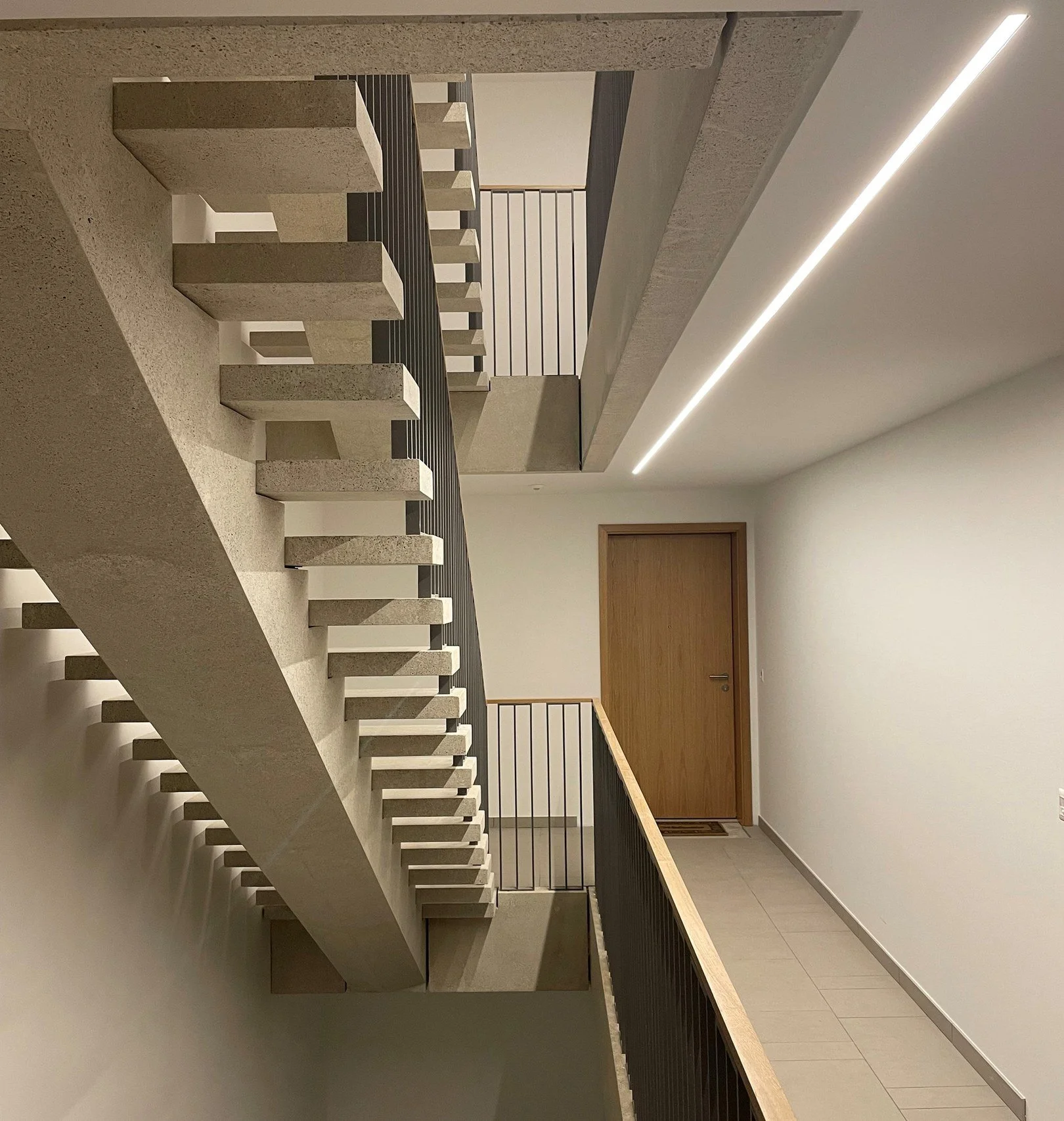 Peinture des parois et faux-plafond avec intégration de bandeau lumineux réalisés par DSD SA dans la cage d'escalier d'un immeuble de logements à Genève