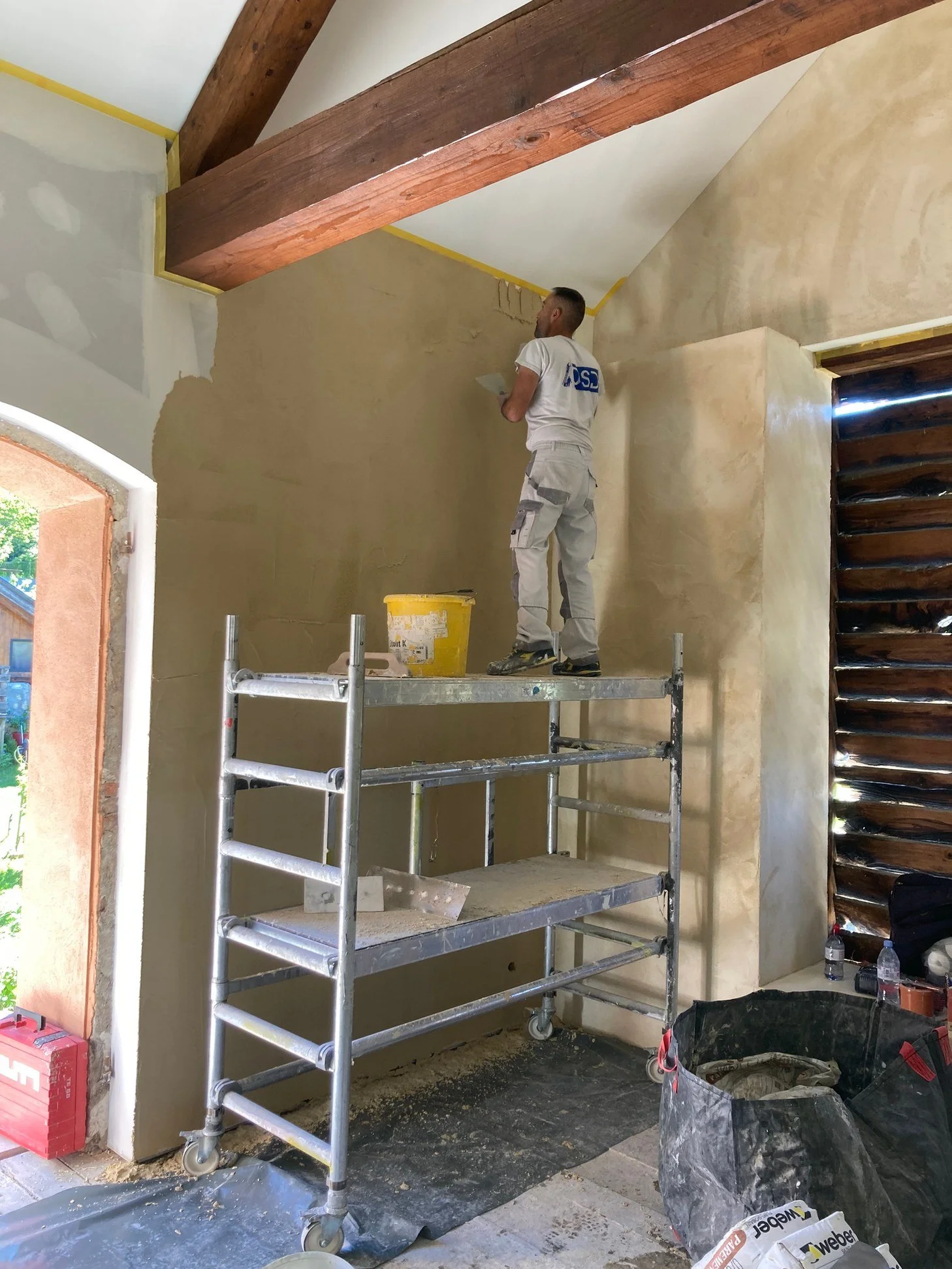 Peintre DSD SA appliquant une finition sur un mur intérieur lors d'un chantier de rénovation à Genève