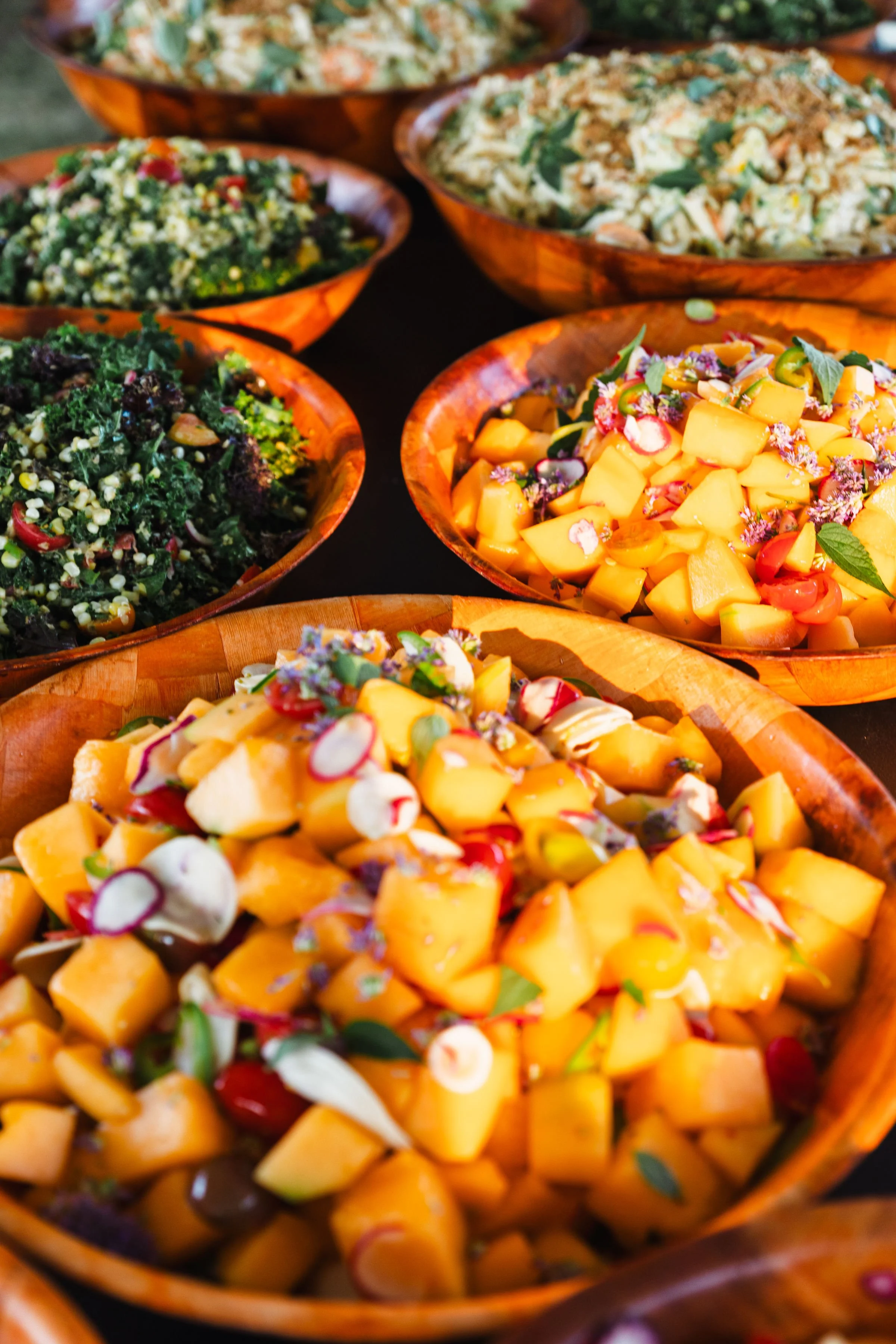 Bowl of diced mango salad garnished with herbs, radish slices, and edible flowers.