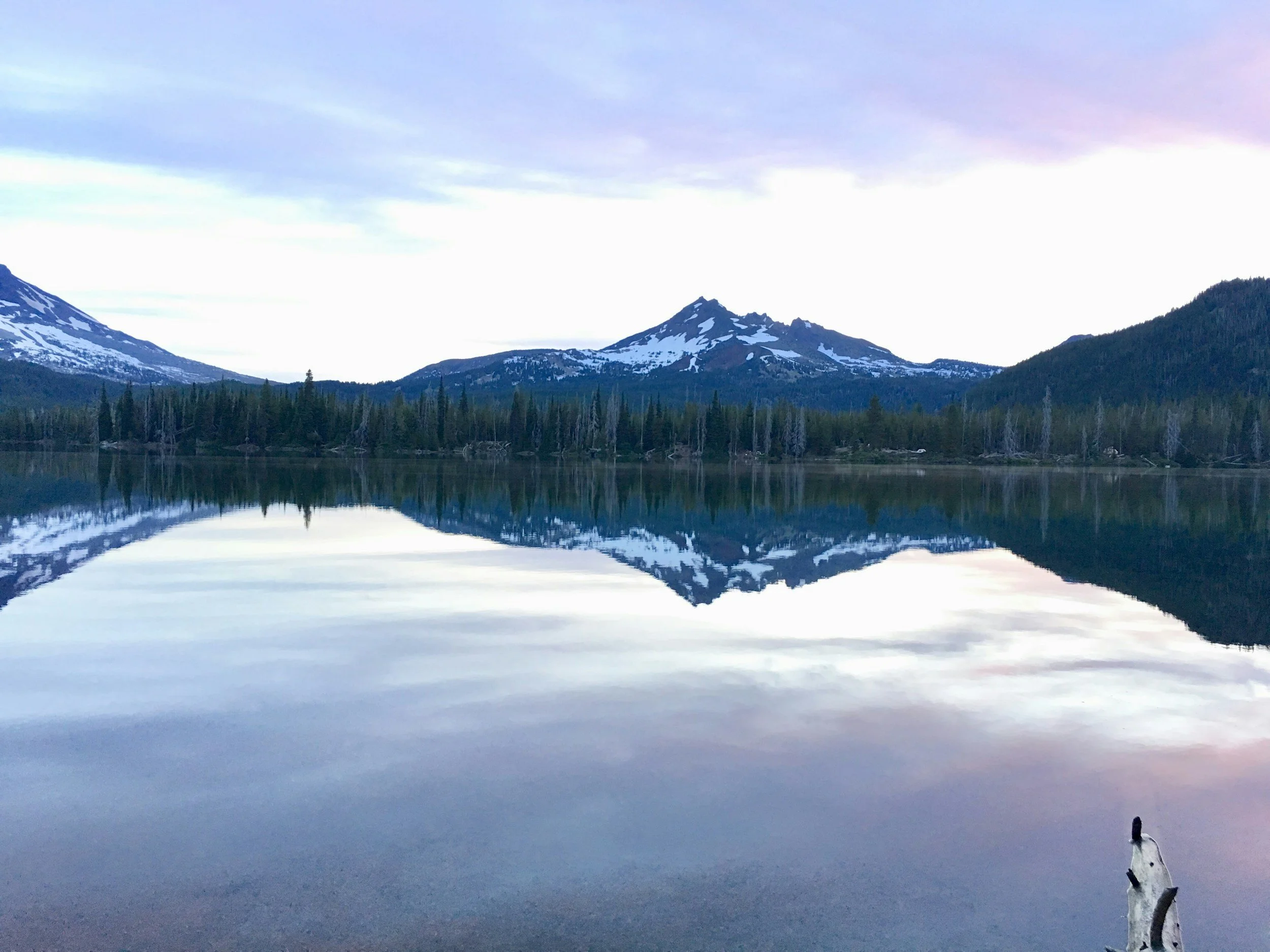 Snow-dusted Cascade peaks reflected in a calm mountain lake.