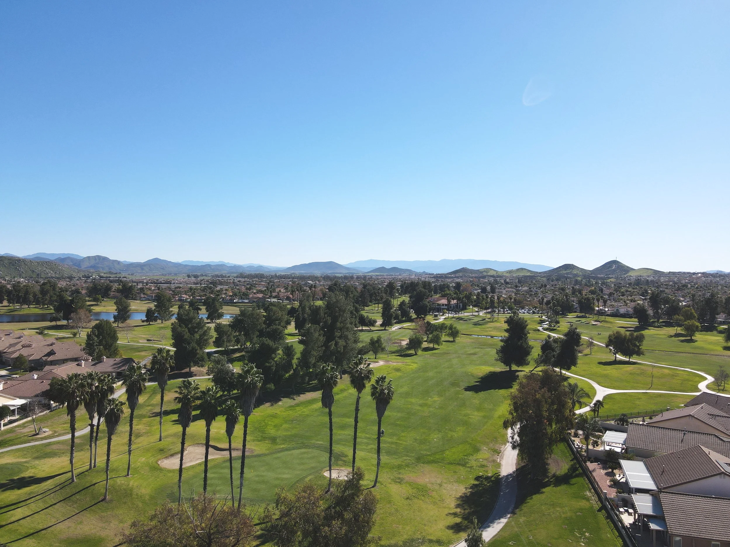 Aerial photograph of Menifee Lakes Country Club with mountain scenery, a golf course and city of Menifee