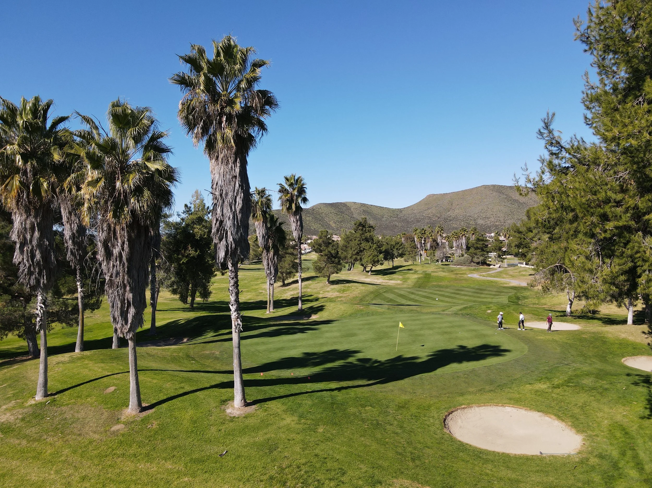 An aerial photography of a Menifee Lakes Country Club putting green with golfers approaching the green 