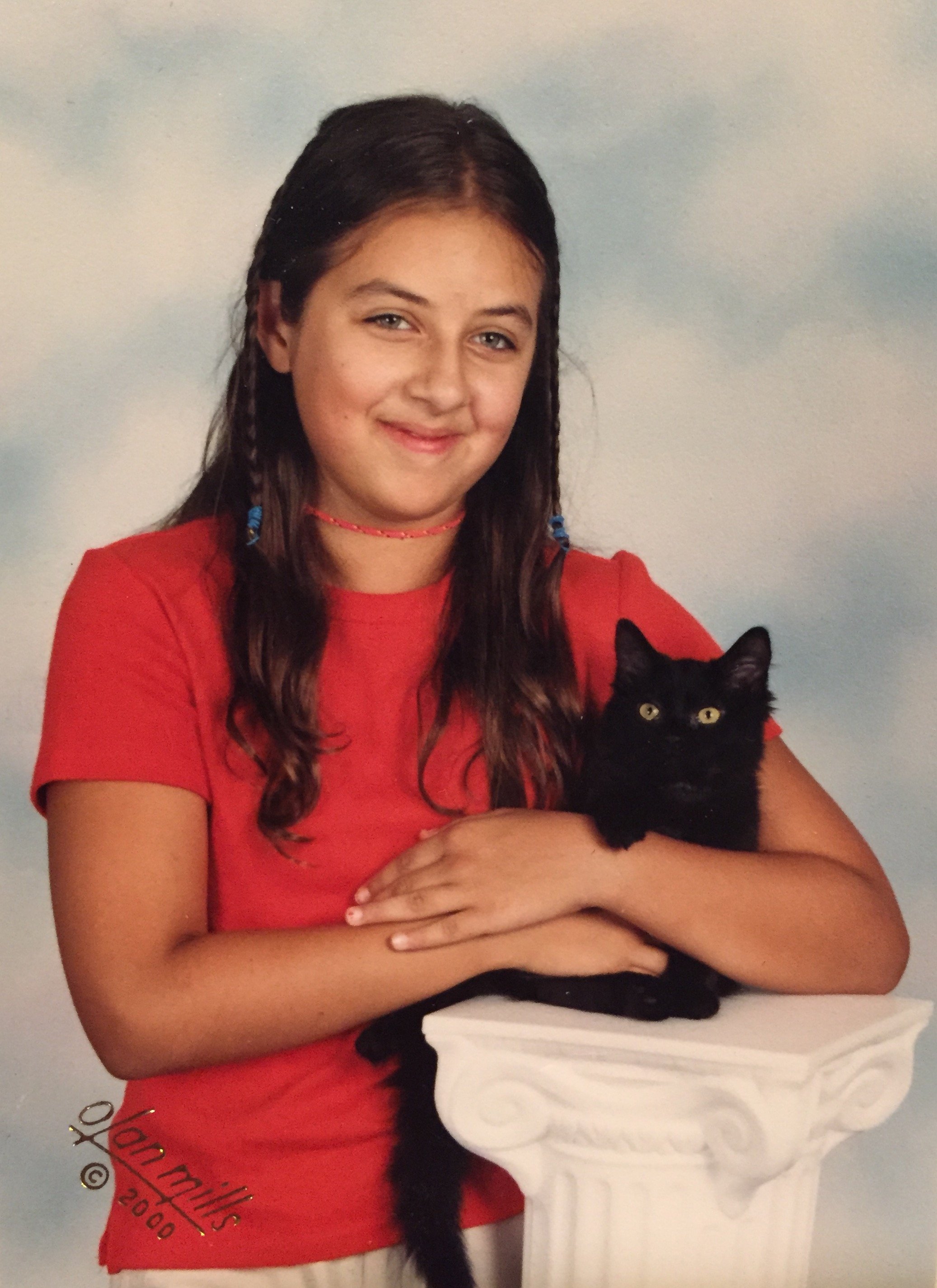 studio photo of preteen child posing with black cat