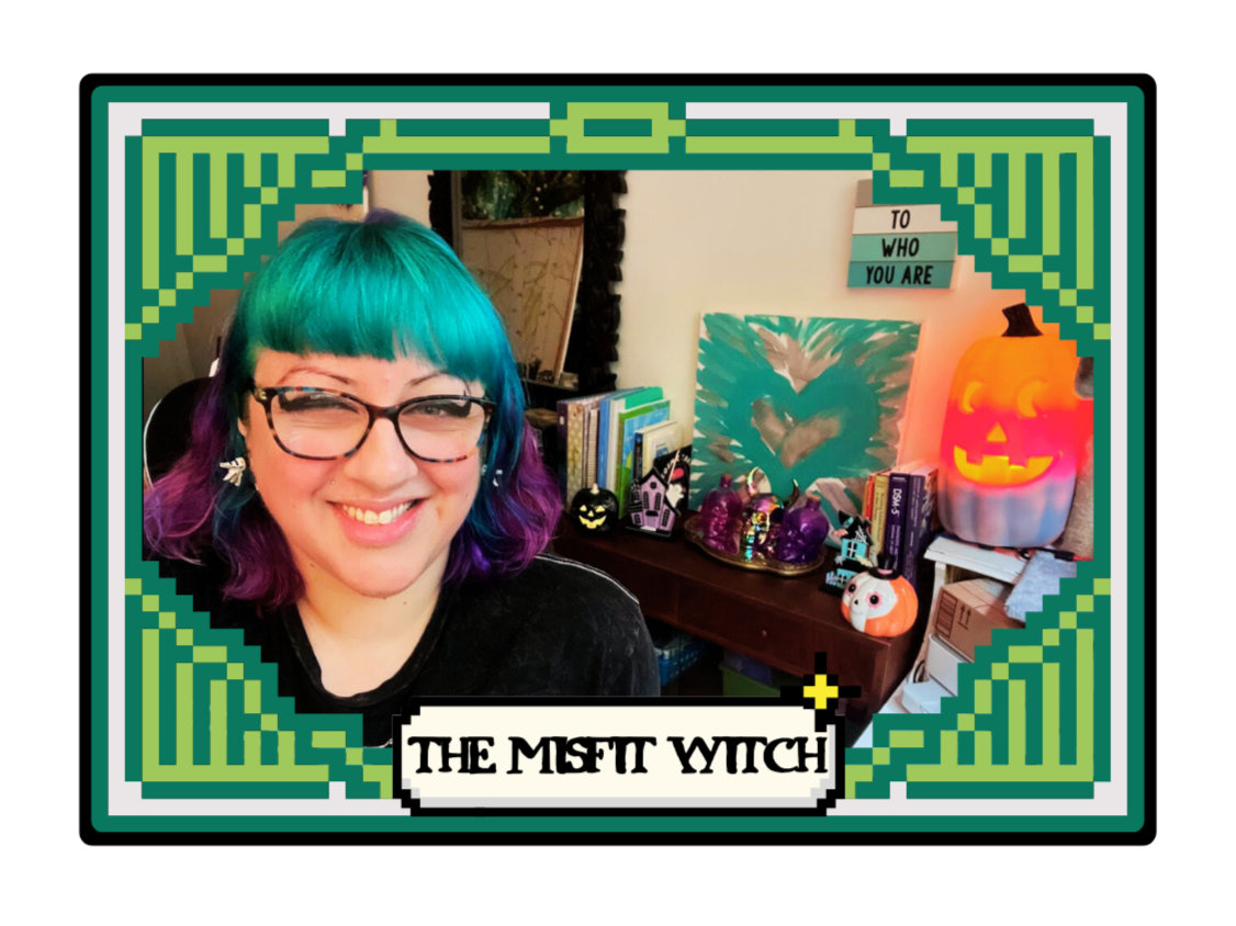 A woman/nonbinary person with teal and purple hair smiling in a room decorated with Halloween and witch-themed items, including pumpkins and skulls, framed by a digital comic-style border with the text "The Misfit Witch" at the bottom.
