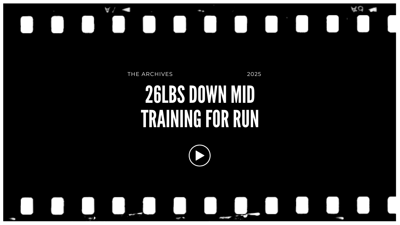 Video thumbnail with a black background and white text that reads "26LBS DOWN MID TRAINING FOR RUN," with smaller text above that says "THE ARCHIVES" and the year "2025." There is a white play button in the center.