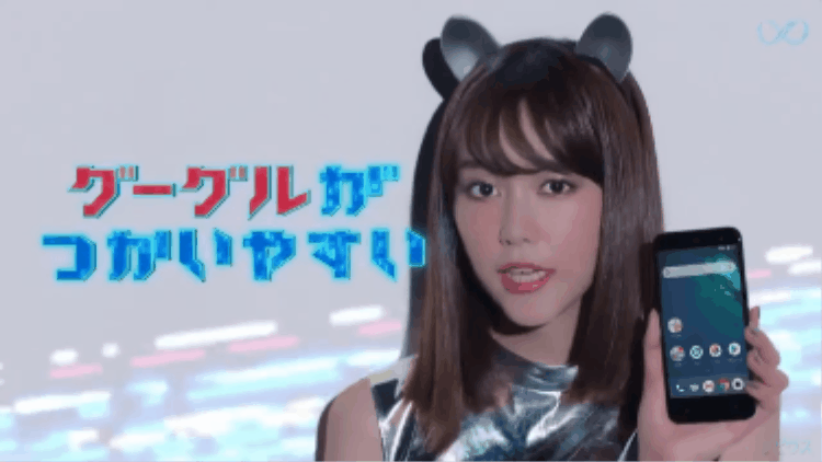 Y! Mobile and Android ad featuring Android One phones in Japan. A young woman with brown hair wearing black bear ear headbands, holding a smartphone, with pixelated Japanese text in the background. Features Yappy (ヤッピー (Yappī)