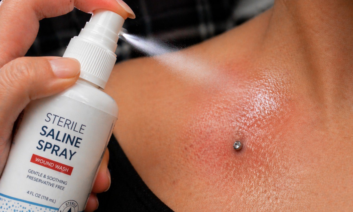 Sterile saline spray being used for professional piercing aftercare and healing