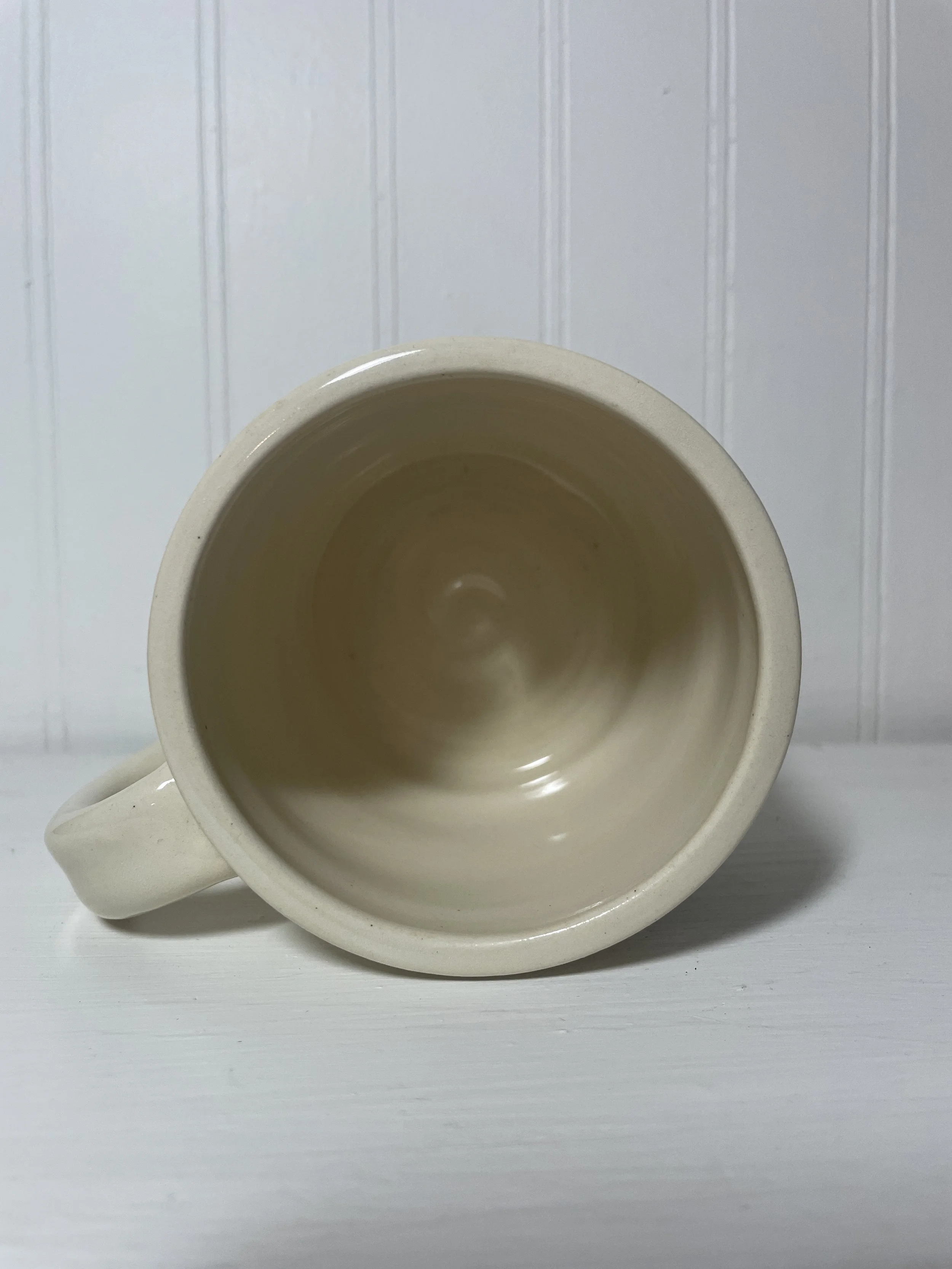a white ceramic mug lying on its side.