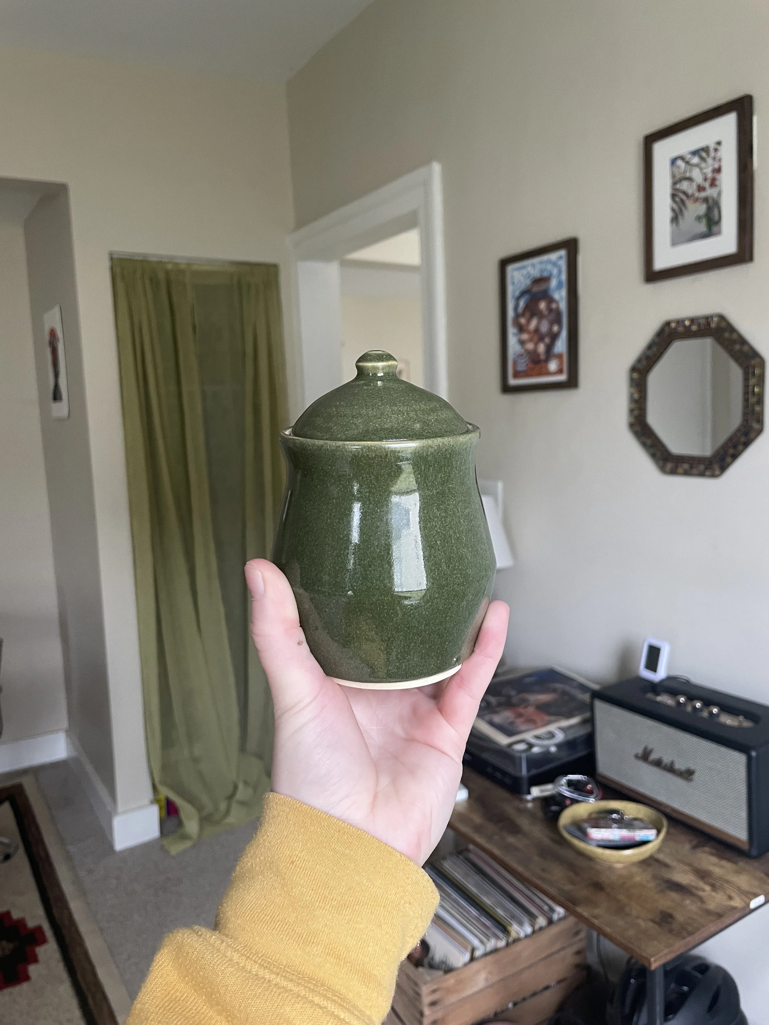 A green ceramic jar with a lid.