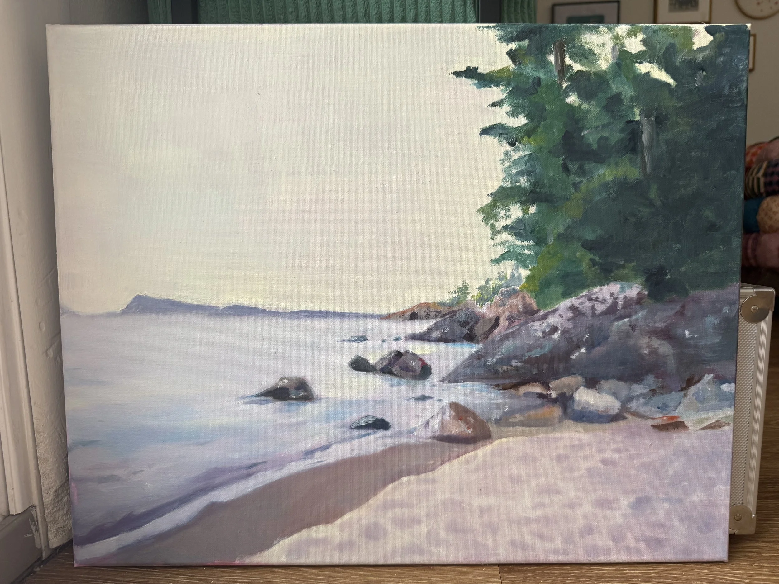 A painting of a lakeside landscape with calm water, rocks along the shoreline, a sandy beach, and a dense green forest on the right side.