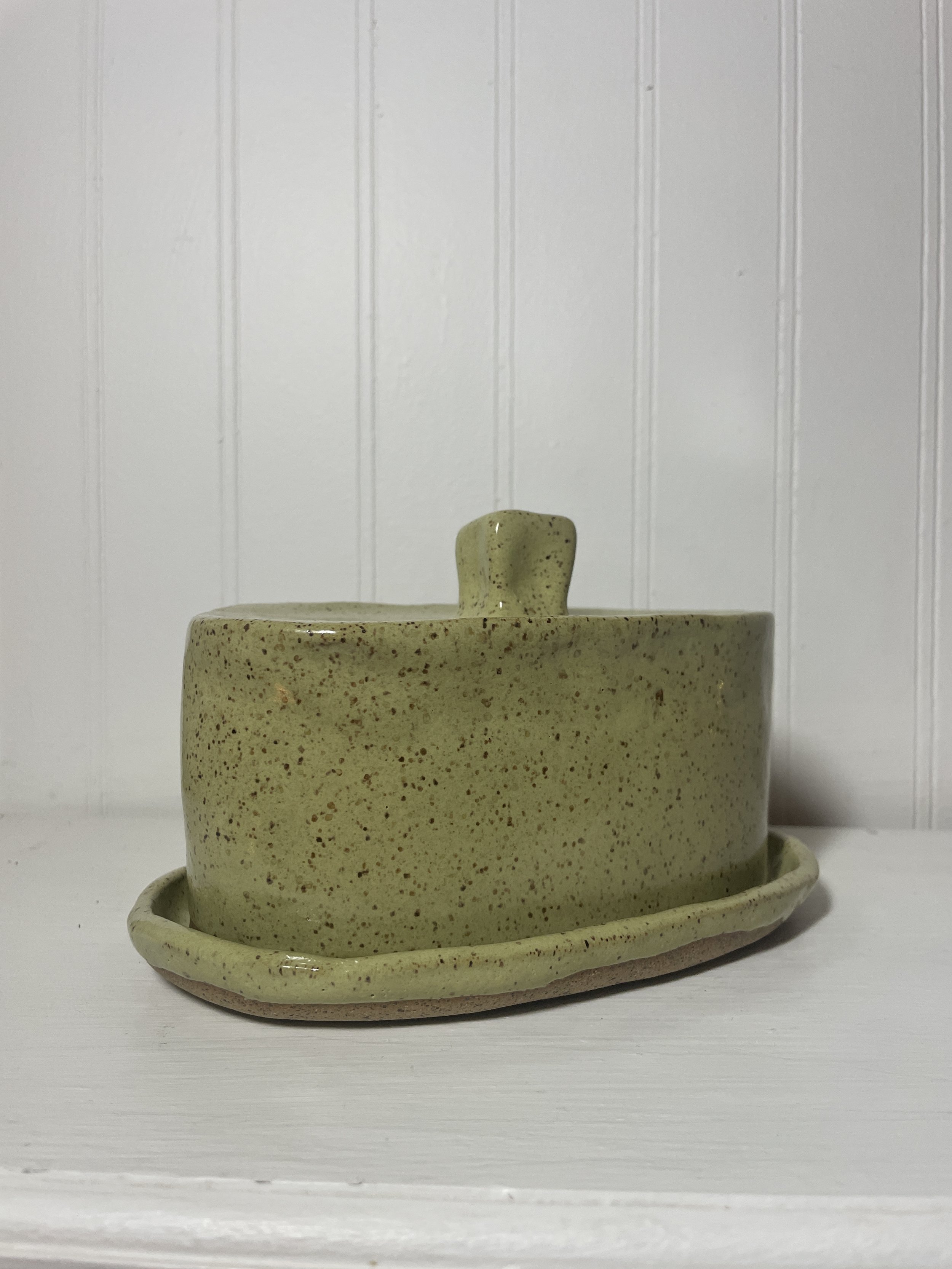 A green ceramic butter dish with a matching lid.