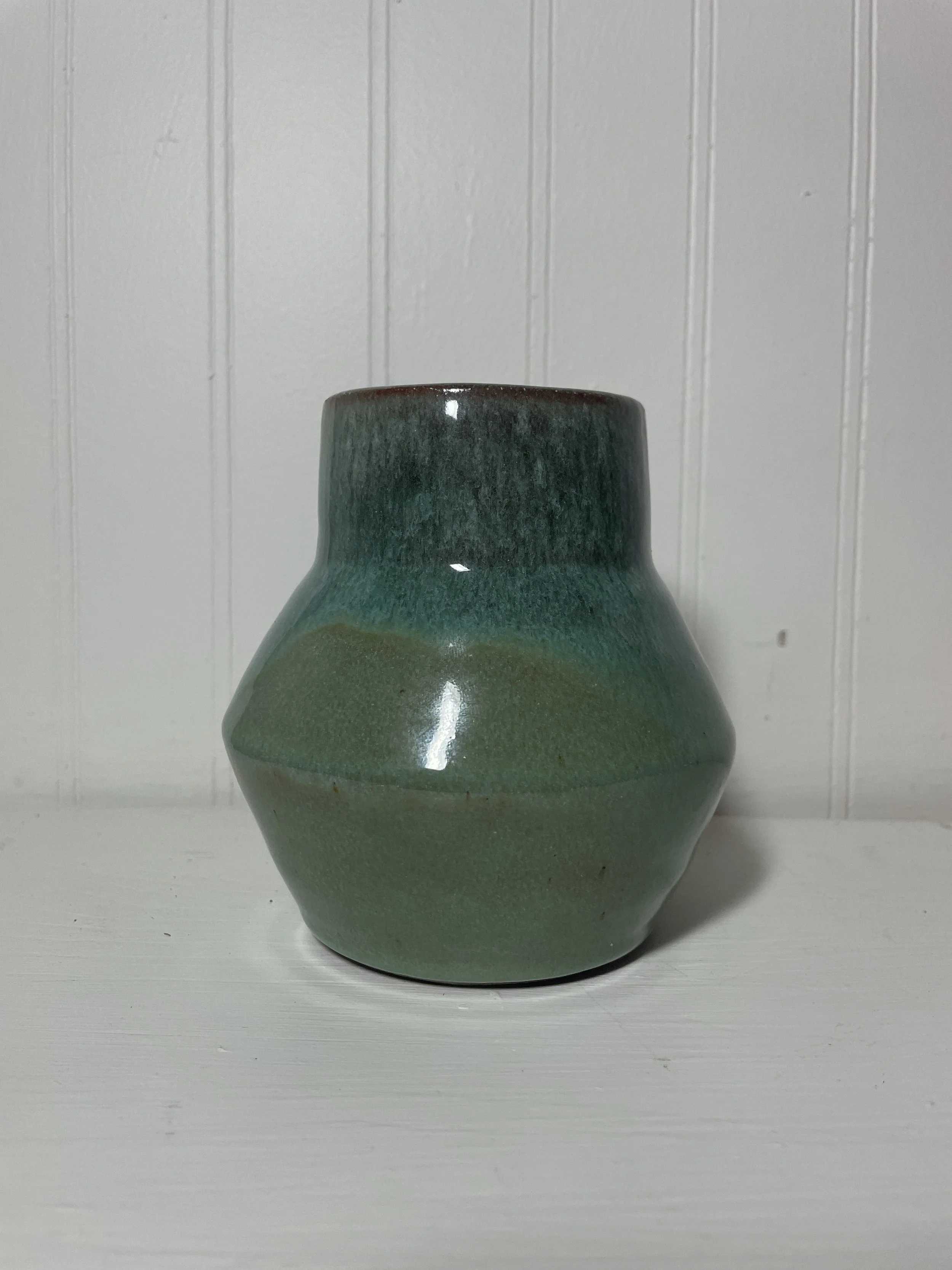 A teal, two-tone ceramic vase.