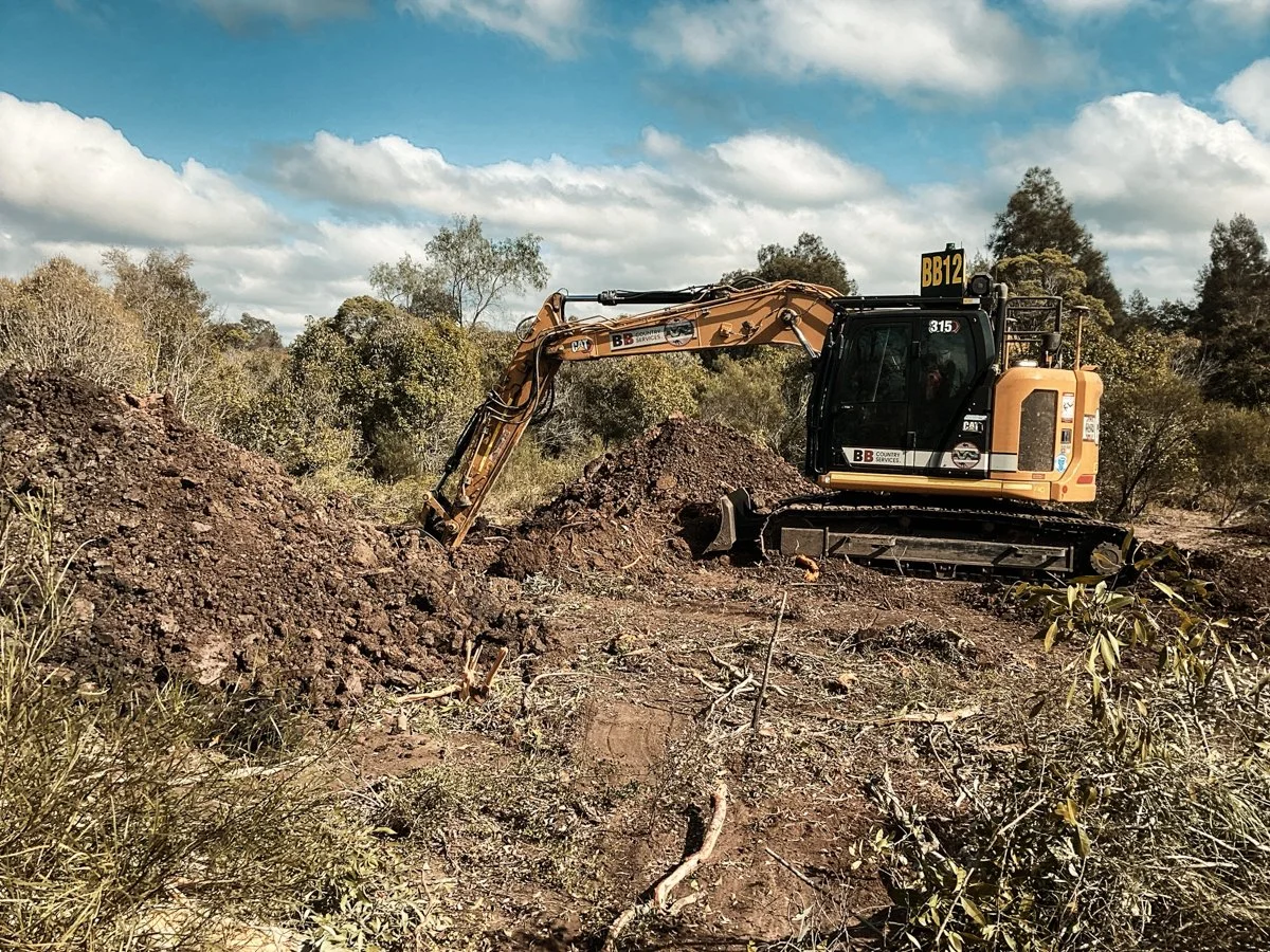 Excavator moving dirt and soil around to make boreholes