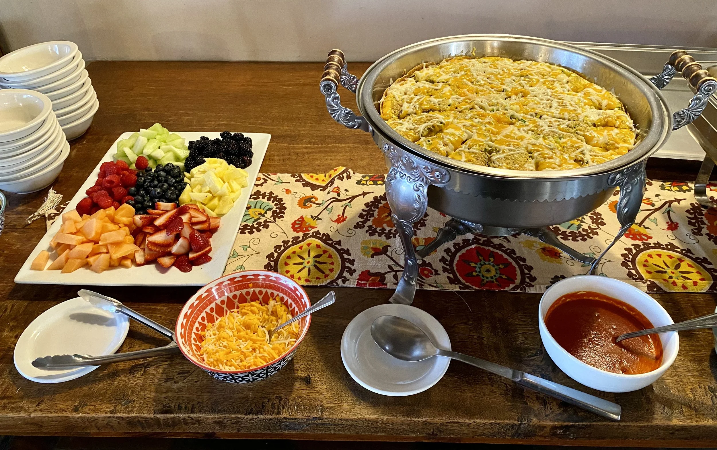 Culinary shots of breakfast bar - set with a plate of fresh fruit, warmed quiche, and condiments to finish.