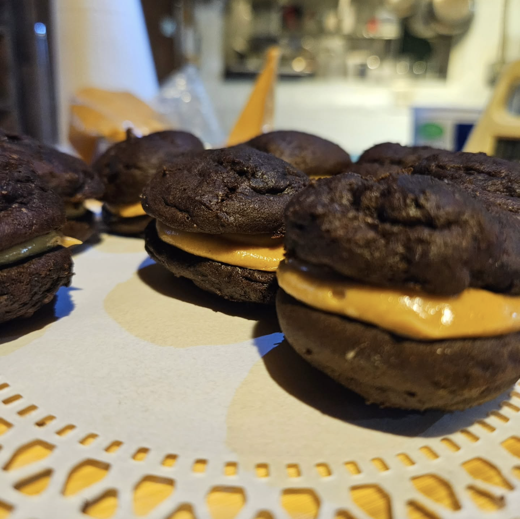 Culinary shots of chocolate cake sandwiches stuffed with a tan caramel fluffy mixure.