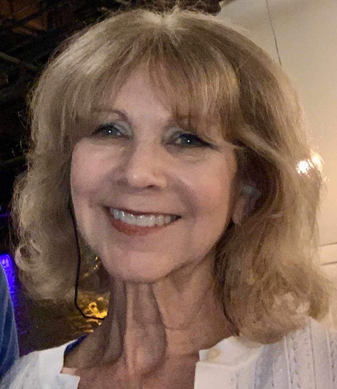 Headshot of Sharon, artistic lead, golden hair with a big smile