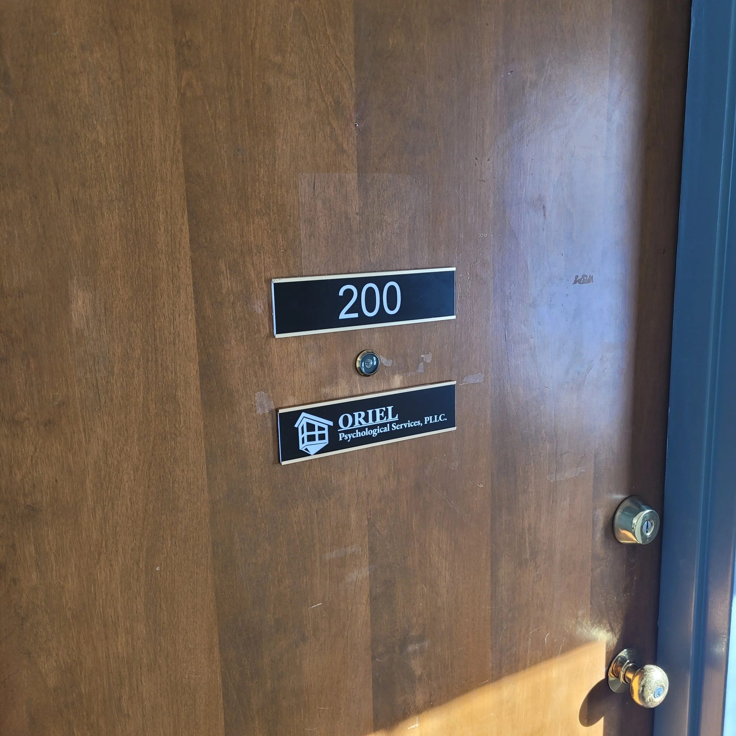 Door with room number 200 and a sign for Oriel Psychological Services, PLLC.