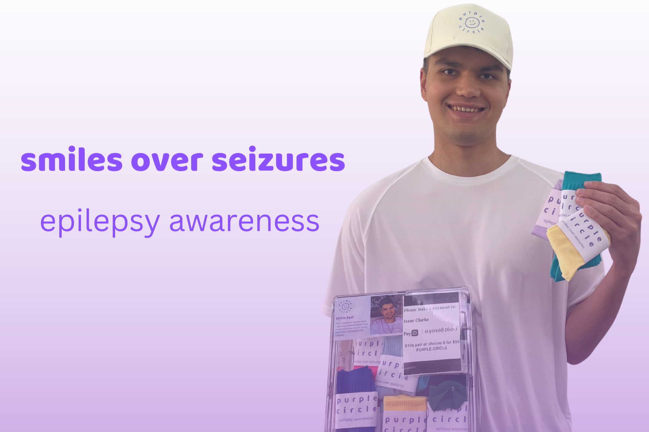 A man wearing a white t-shirt and beige baseball cap smiling at the camera, holding colorful socks with purple labels that read 'purple circle'. There is a clear donation box in front of him containing more socks and a shirt, with a photo and name tag of a person named Isaac Clarke. The background is light purple with text promoting epilepsy awareness and encouraging smiles over seizures.