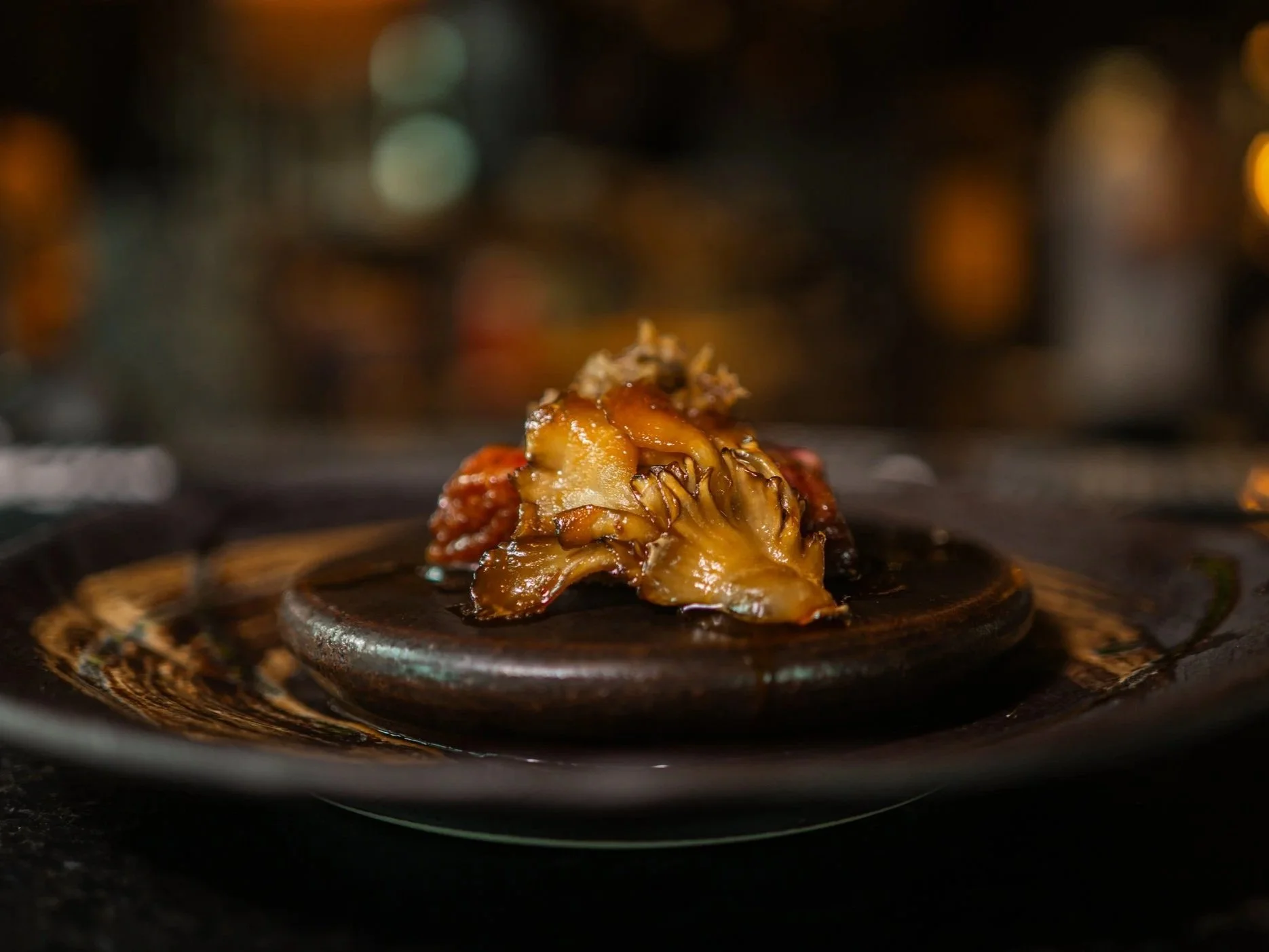A gourmet Japanese mushroom and truffle course served on a heated stone plate at Yugen.
