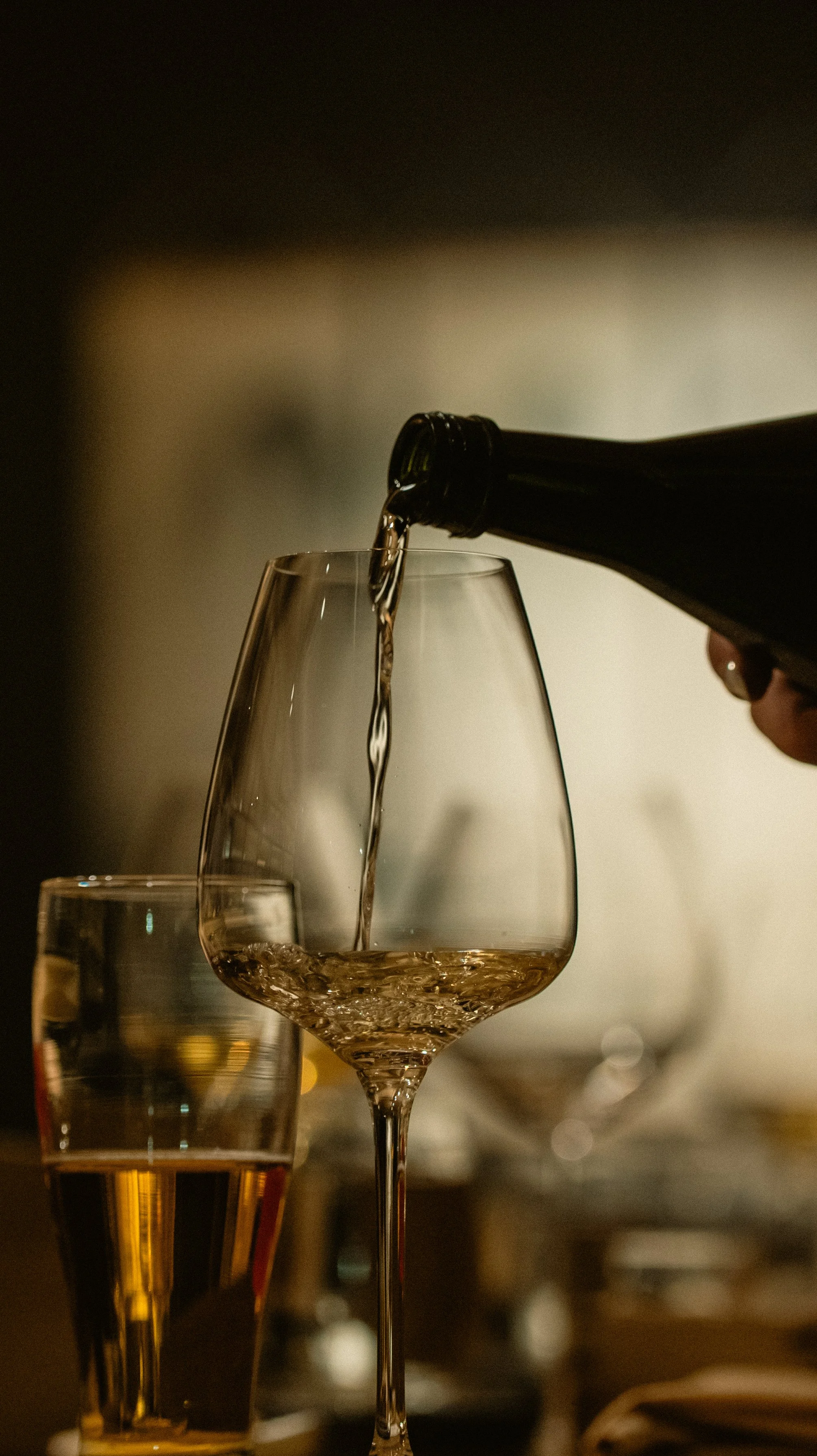 A sommelier pouring a premium sake pairing into a crystal glass at Yugen’s intimate beverage station.