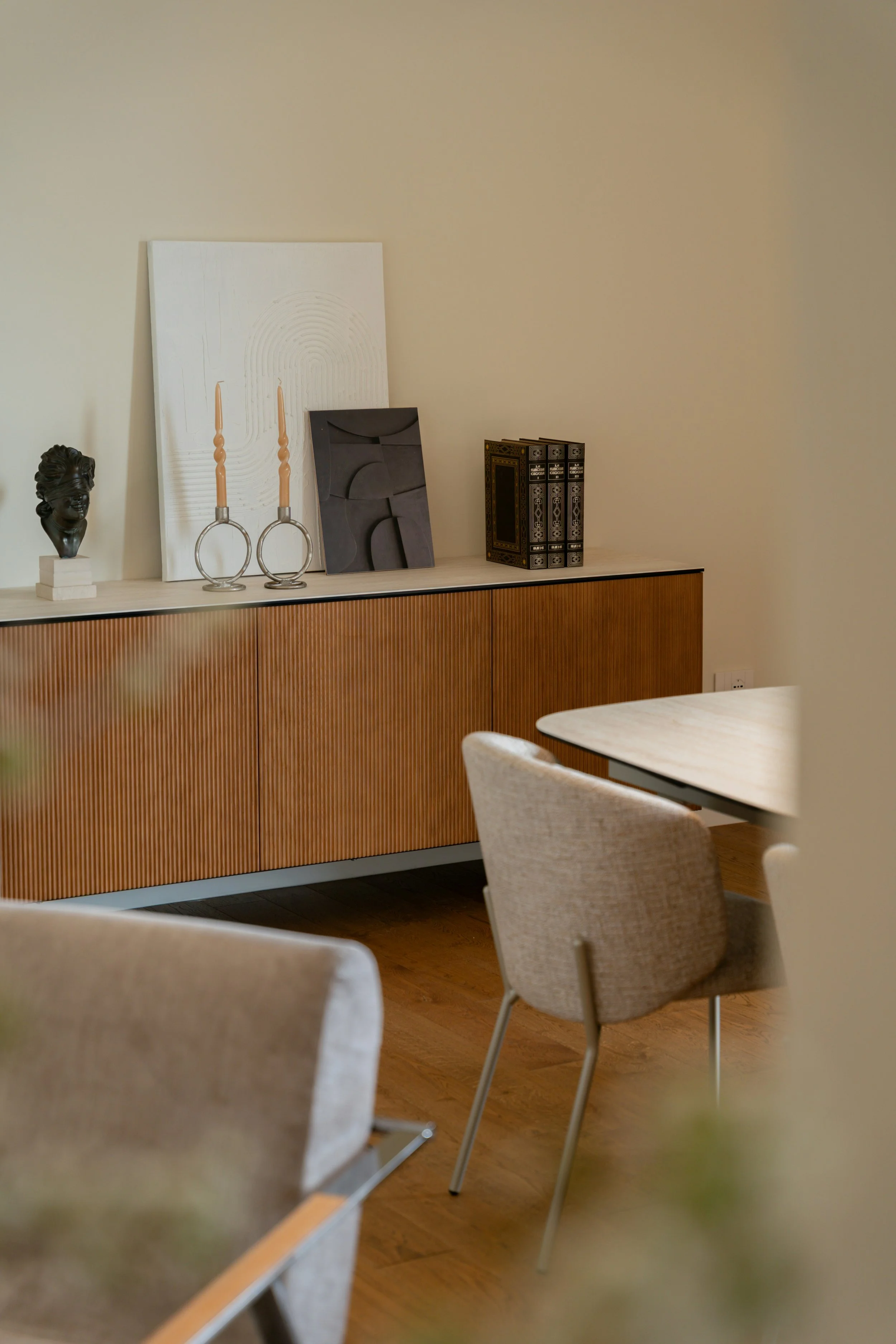 A mid-century modern armchair with mustard-yellow upholstery and wooden arms and legs, placed in a corner of a room with beige carpet and plain white walls.