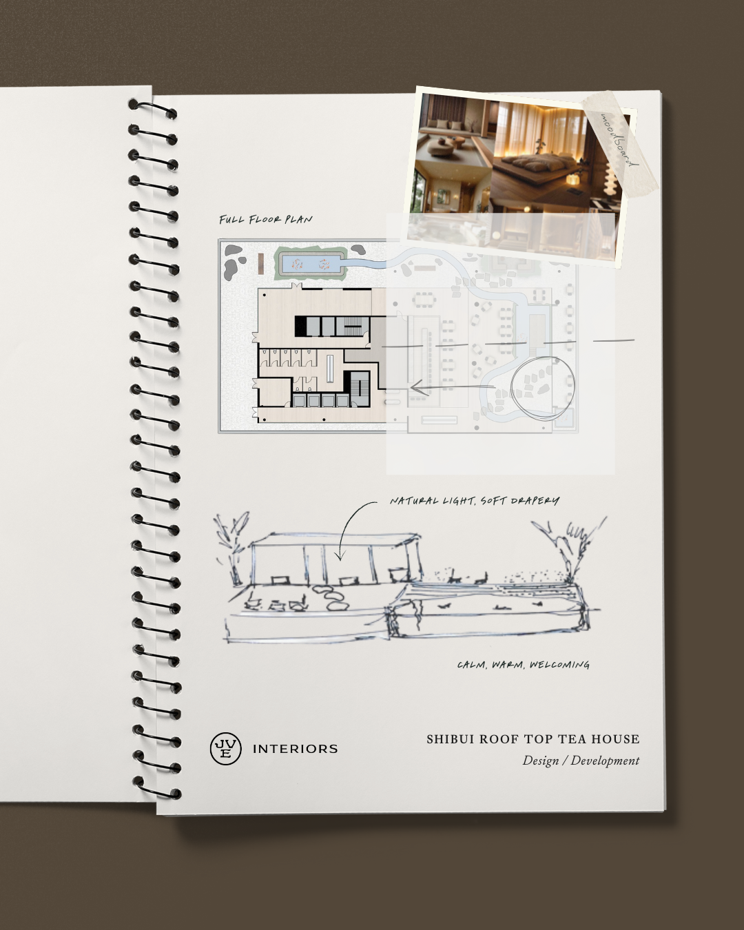 Modern living room with a black round speaker on three legs, a black wall-mounted TV, a vase with red berries and greenery, a small white teapot and cups on a dark round coffee table, and a warm-colored wooden chair in the foreground.