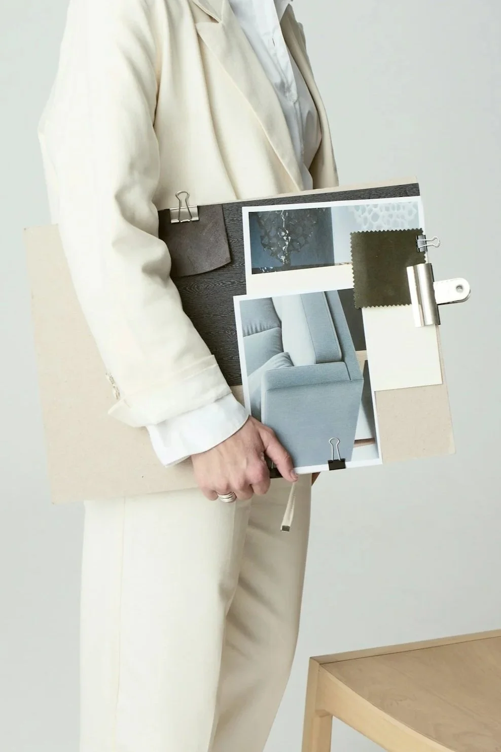 A small ceramic vase with a narrow neck and rounded body, featuring a brown glaze and white base, is placed on a white surface against a plain neutral background.