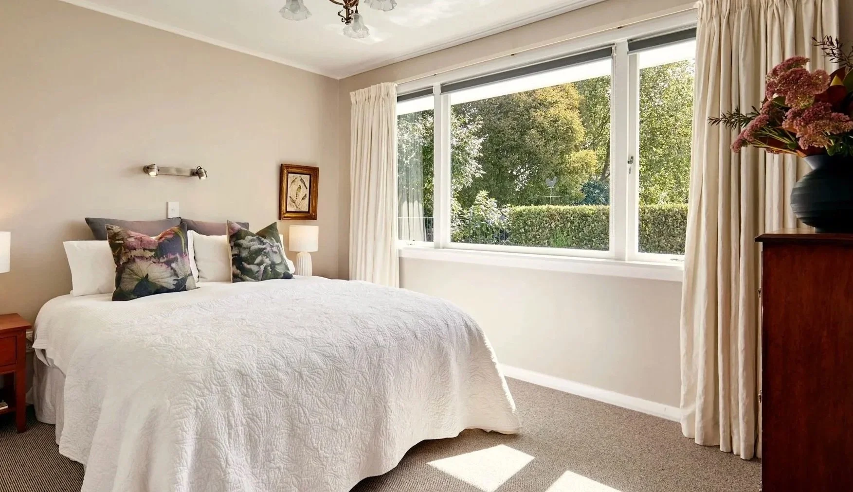 Light-filled bedroom at Eliza's Garden Cottage overlooking the garden and private pool with quality linen and a comfortable bed.