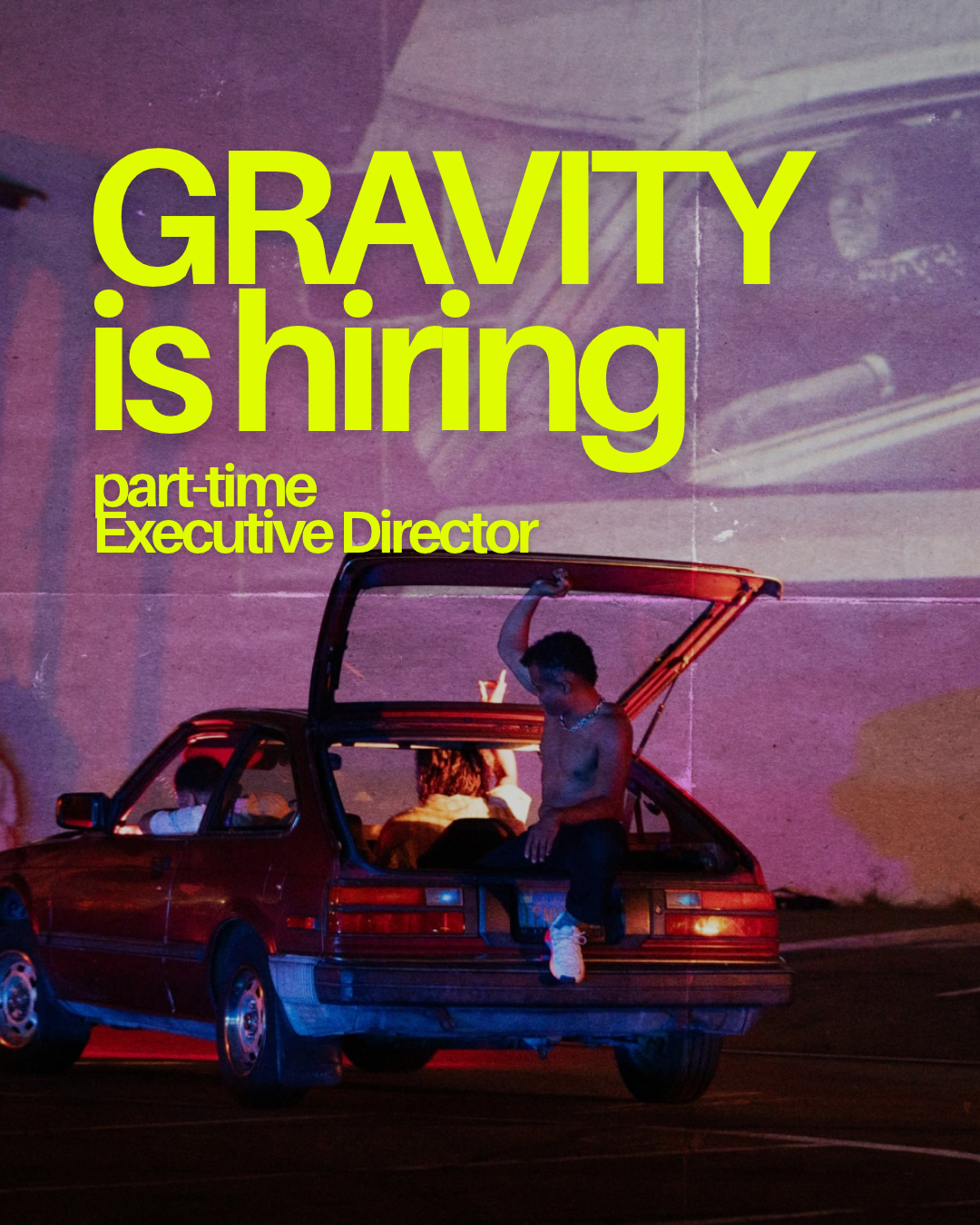 A person stands in the back of an open car trunk at night, with bright red and blue neon lighting, while another vehicle is parked beside it under a purple-lit wall. text reads GRAVITY is hiring part time Executive Director