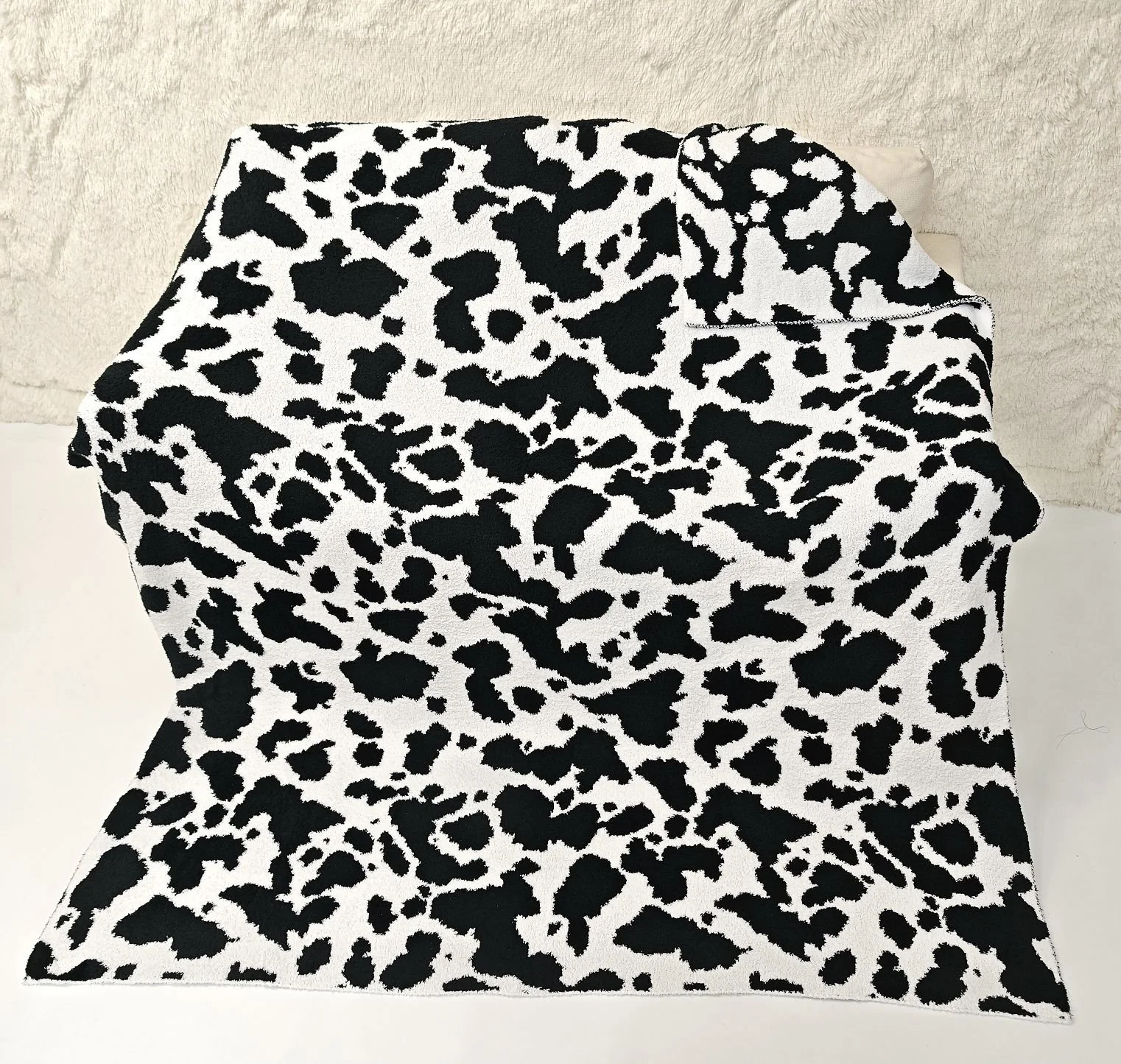 Stylish knitted throw with cow design