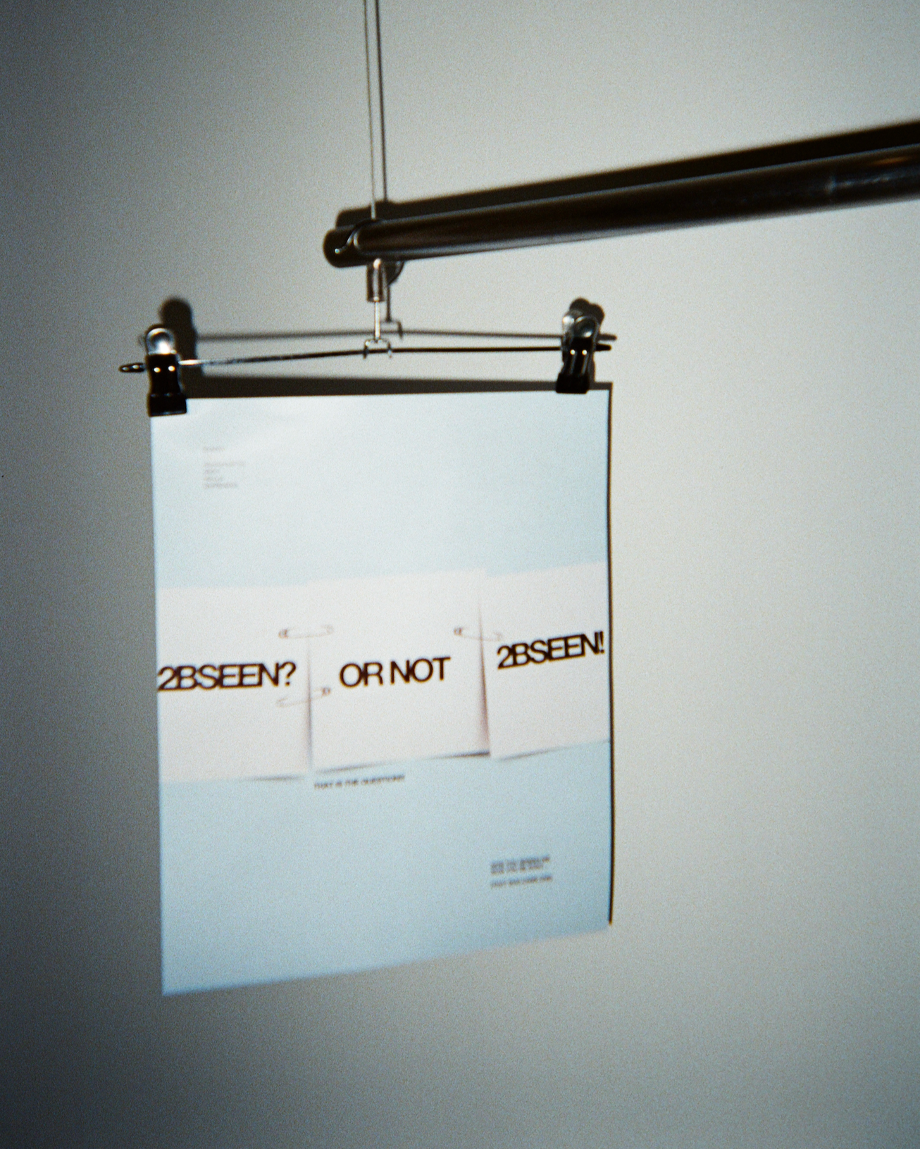 Hanged poster with text '2BSEEN? OR NOT 2BSEEN!' on a wall.