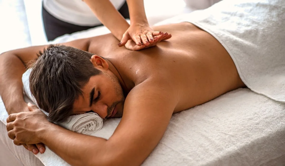Man receiving a back massage while lying face down on a massage table