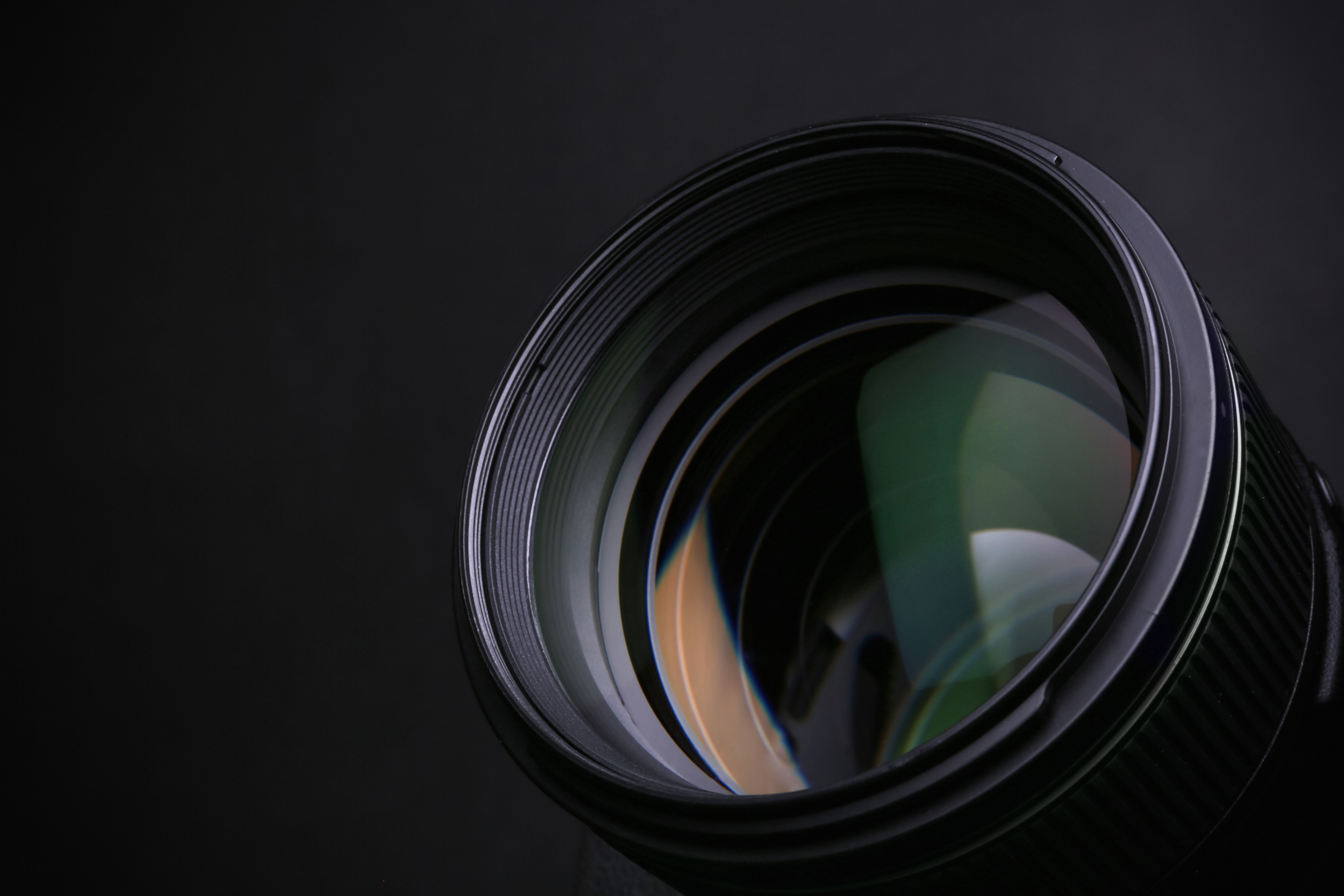Close-up of a camera lens against a dark background.
