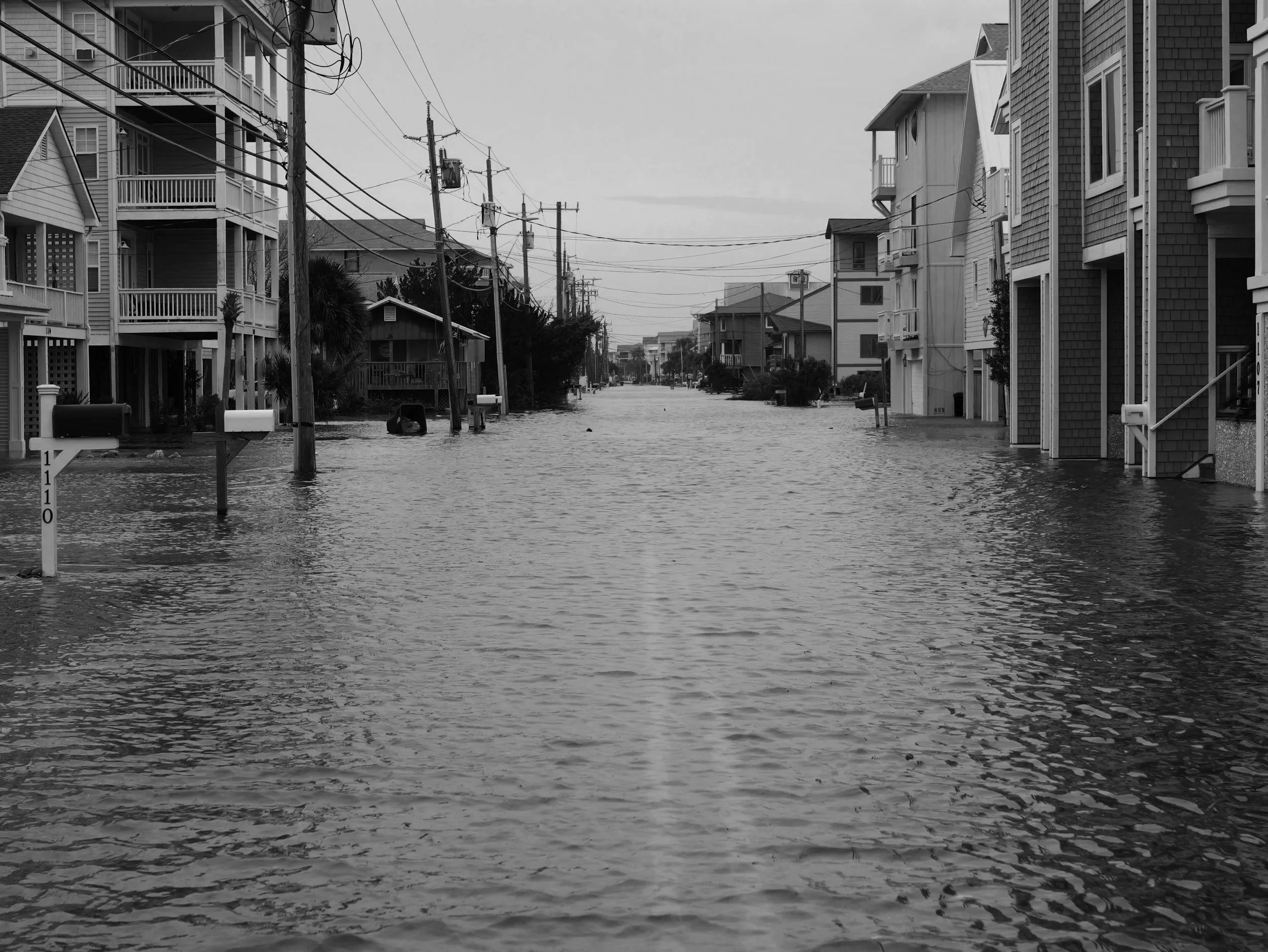 a flood shown in a road with broken buildings