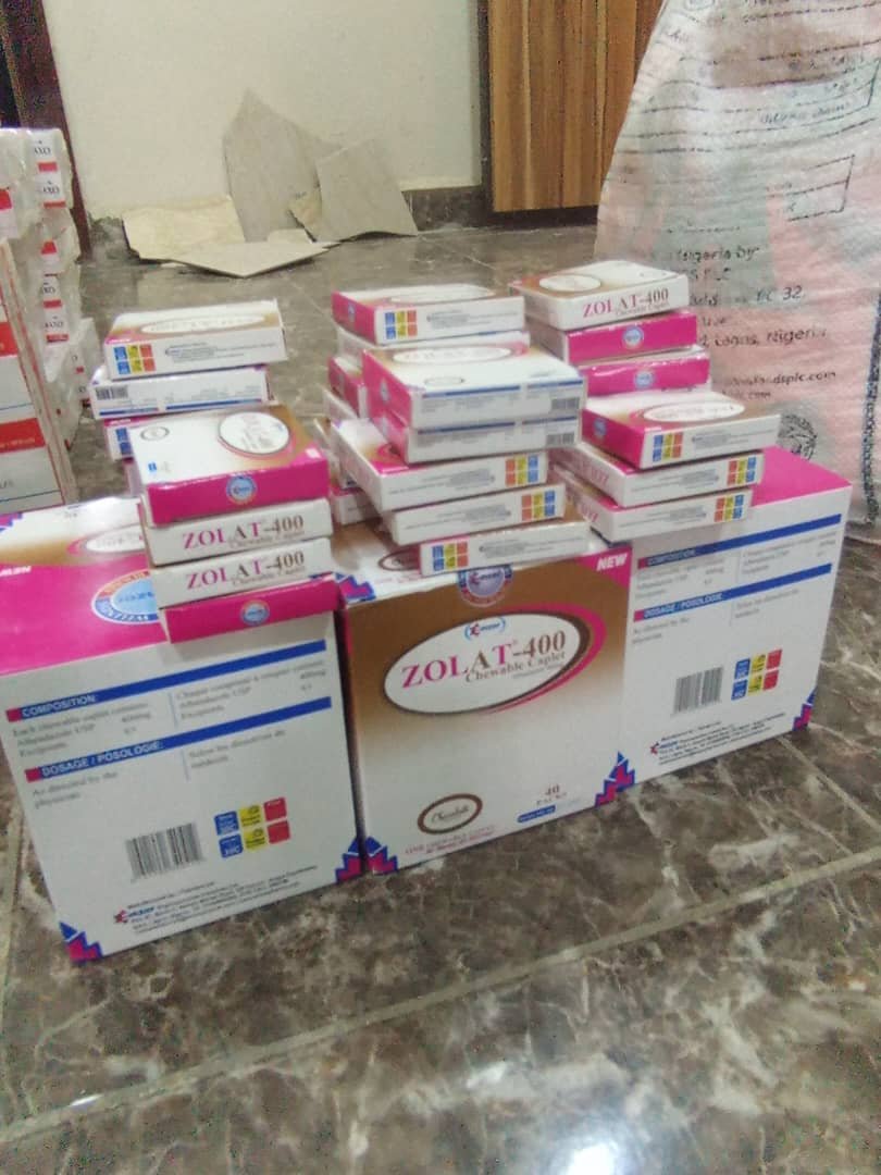 Multiple boxes of Zol AT-400 Chewable Tablets stacked on a tiled floor in a room.